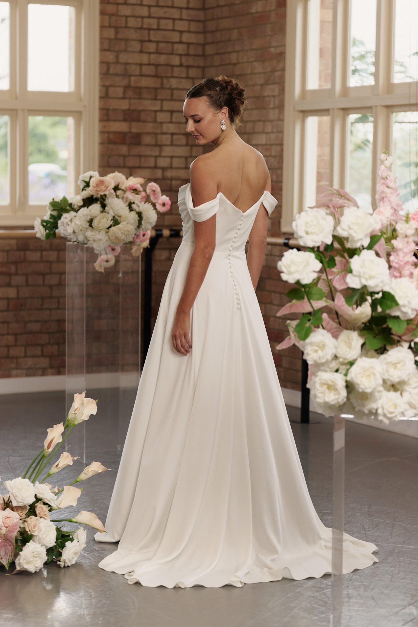 Back of Anne wedding dress showing button down back and flowing A-line crepe skirt.