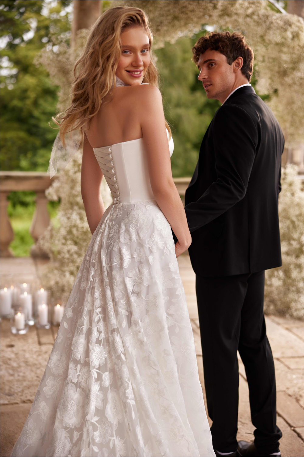 Strapless wedding dress featuring a structured bodice, romantic sweetheart neckline, and voluminous floral tulle skirt.