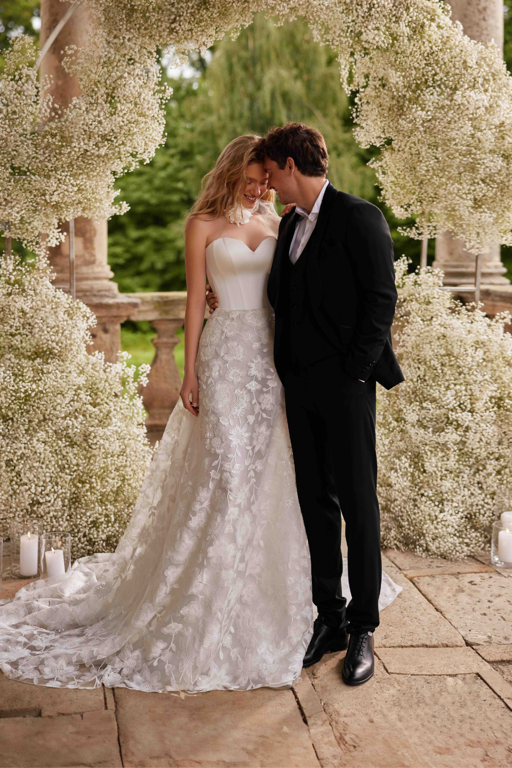 Princess wedding dress with a plain structured bodice, sweetheart neckline, and delicate floral tulle skirt.