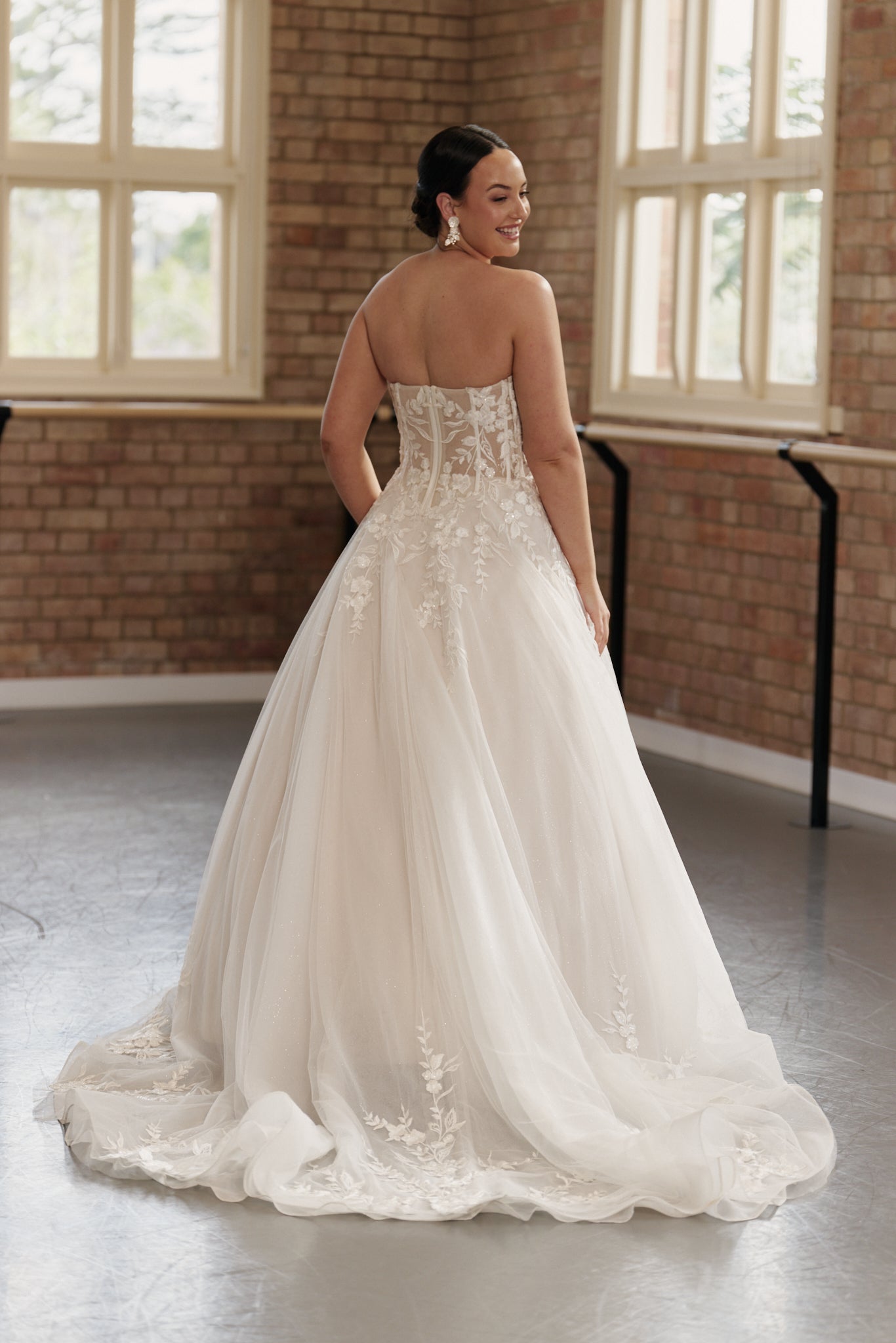 Back view of the Camille bridal gown showcasing medium-length train and embroidered bodice flowing into tulle skirt.
