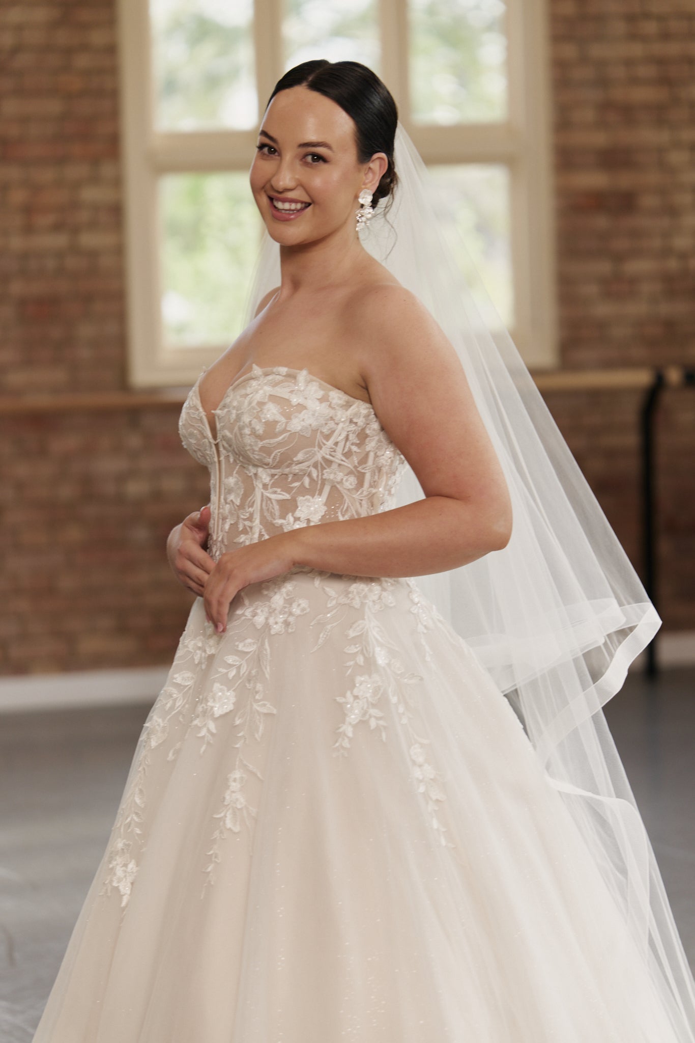 Side profile of the Camille gown highlighting strapless structured bodice and flowing embroidered princess skirt.