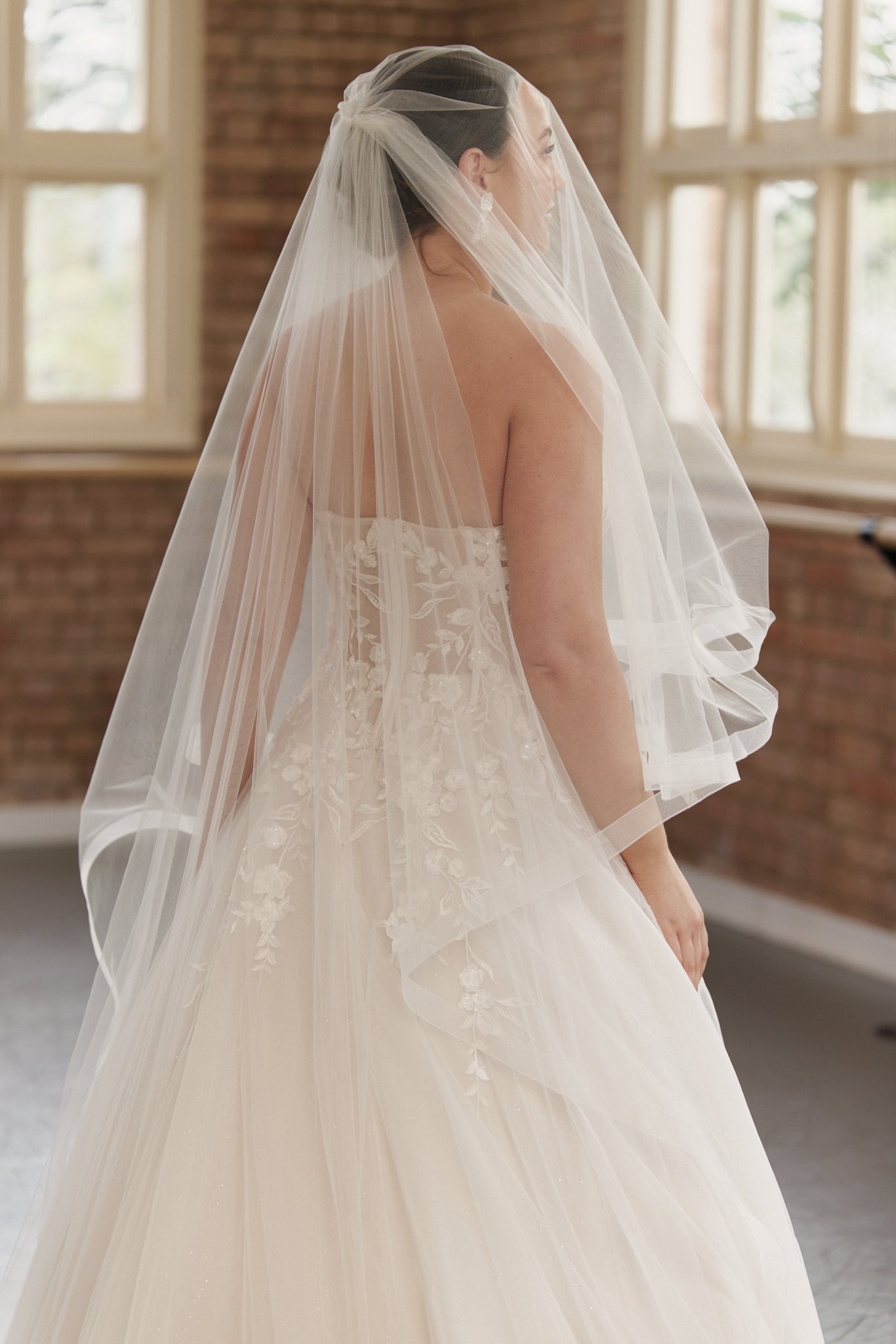 Close-up of the Camille gown’s strapless structured bodice and intricate embroidery on bodice flowing into tulle skirt.
