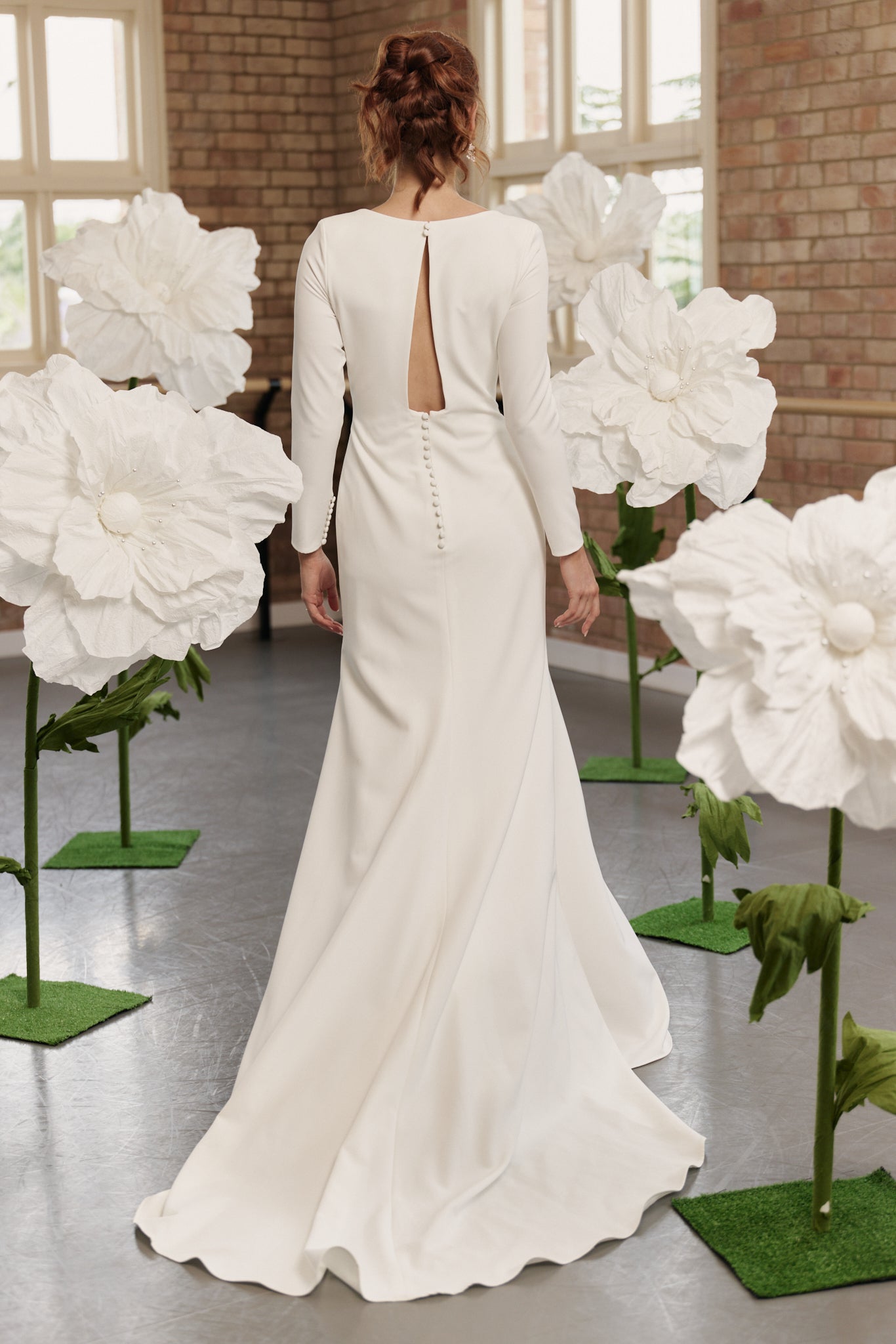 Back of Charlotte mermaid wedding dress with open back, long sleeves, and square neckline in soft crepe.