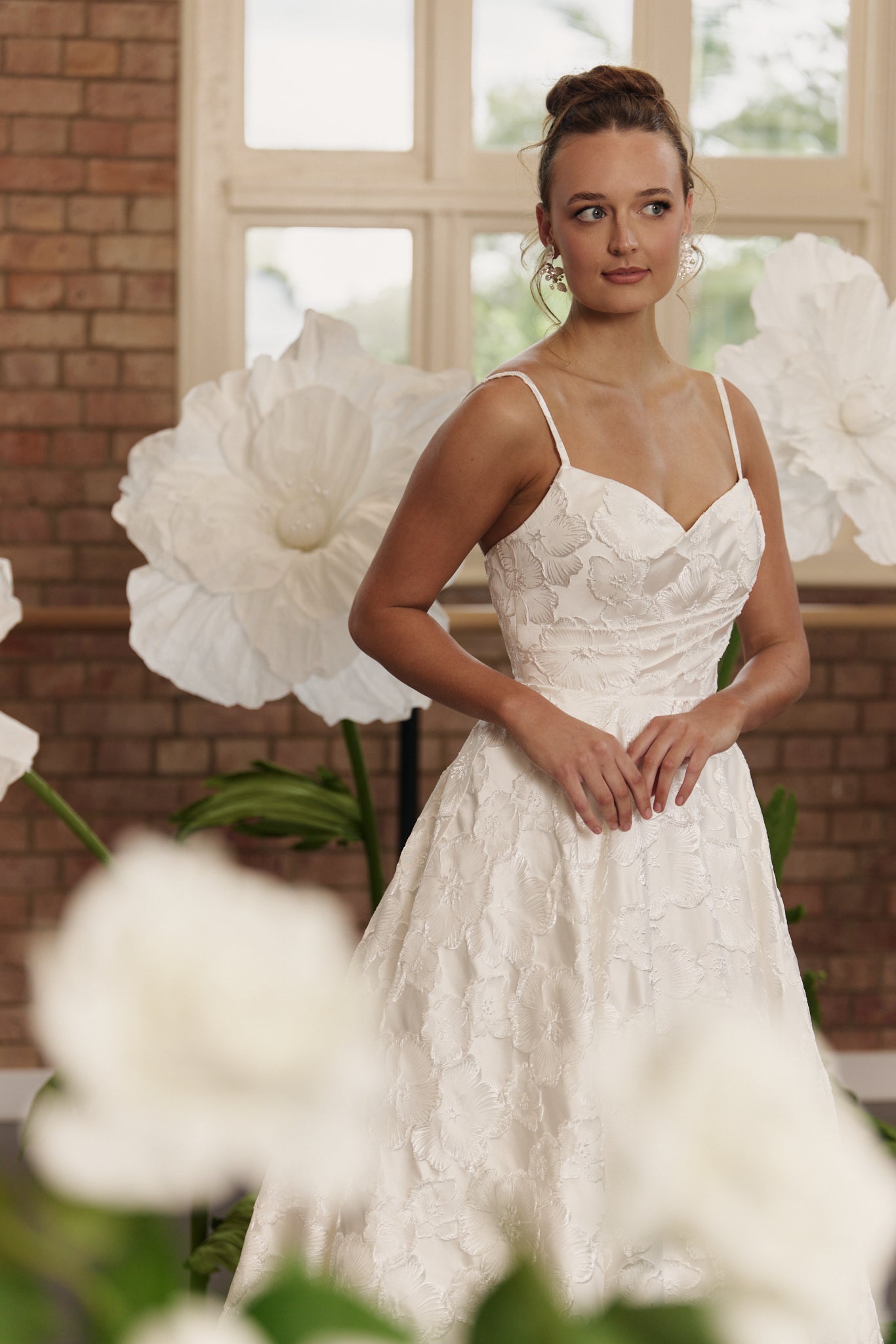 Close-up of structured bodice and floral jacquard fabric on wedding dress with cinched waist