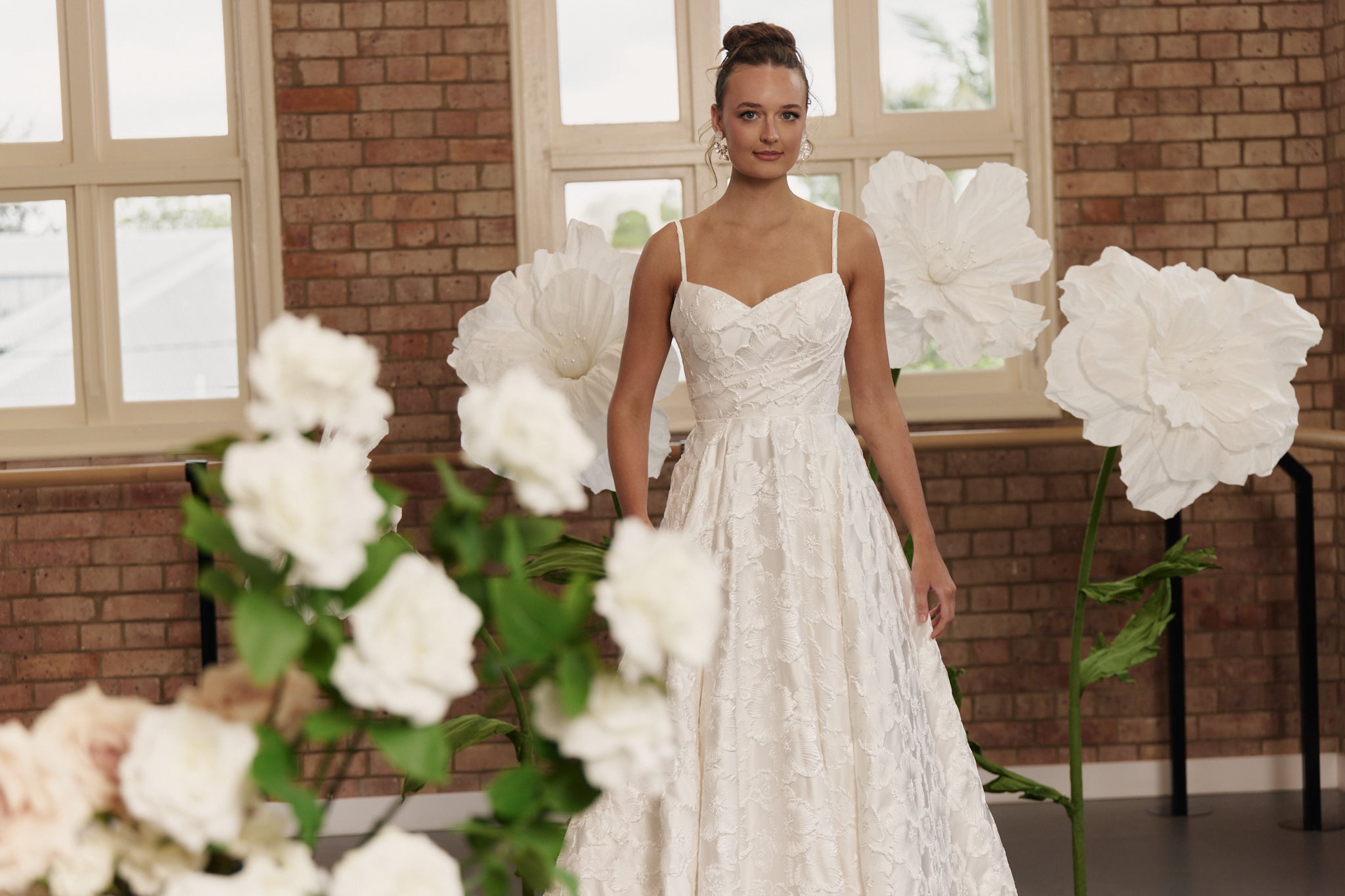 Close-up of structured bodice and floral jacquard fabric on wedding dress with cinched waist.