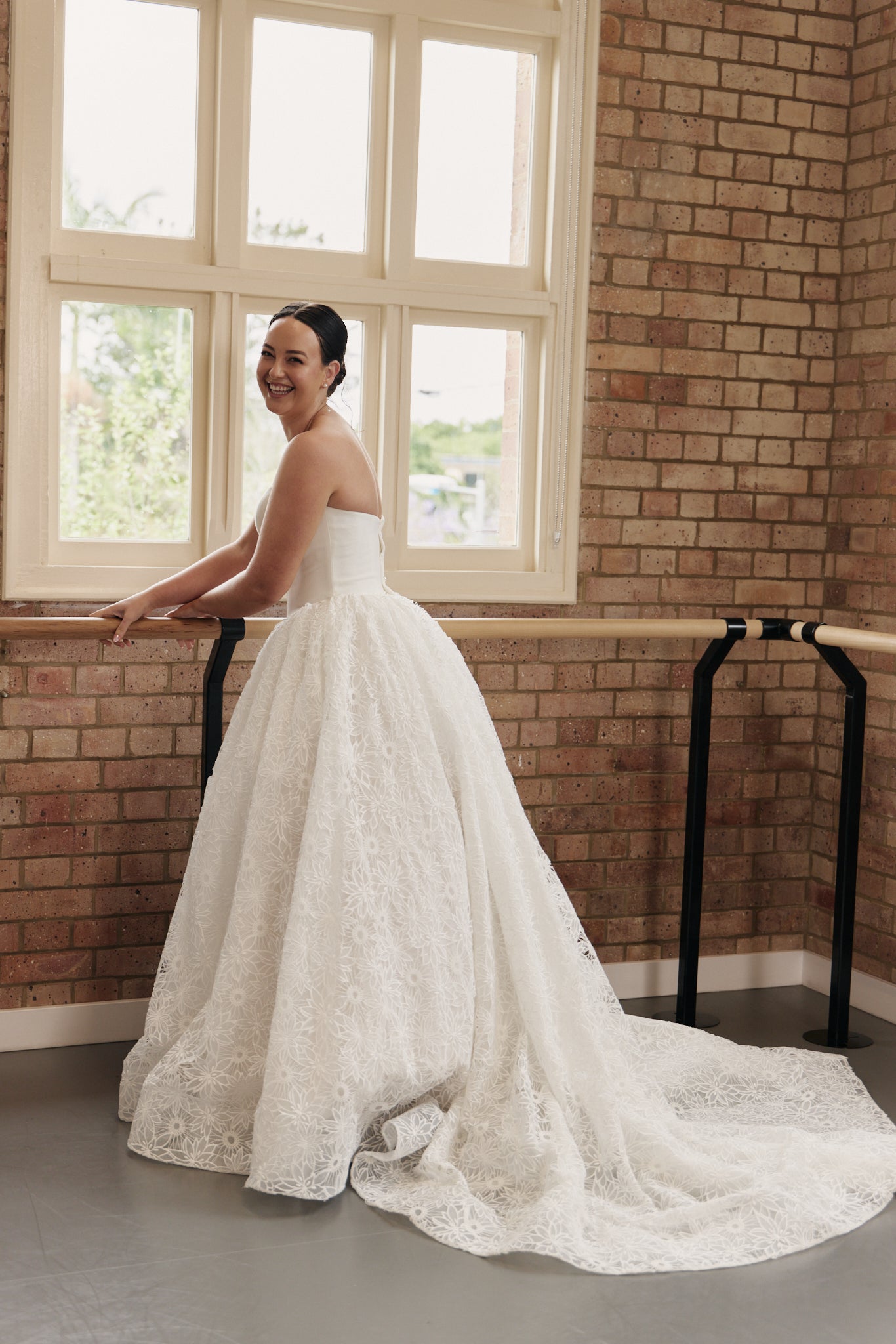 Back of Danielle wedding dress featuring strapless sweetheart bodice and flowing floral lace princess skirt.