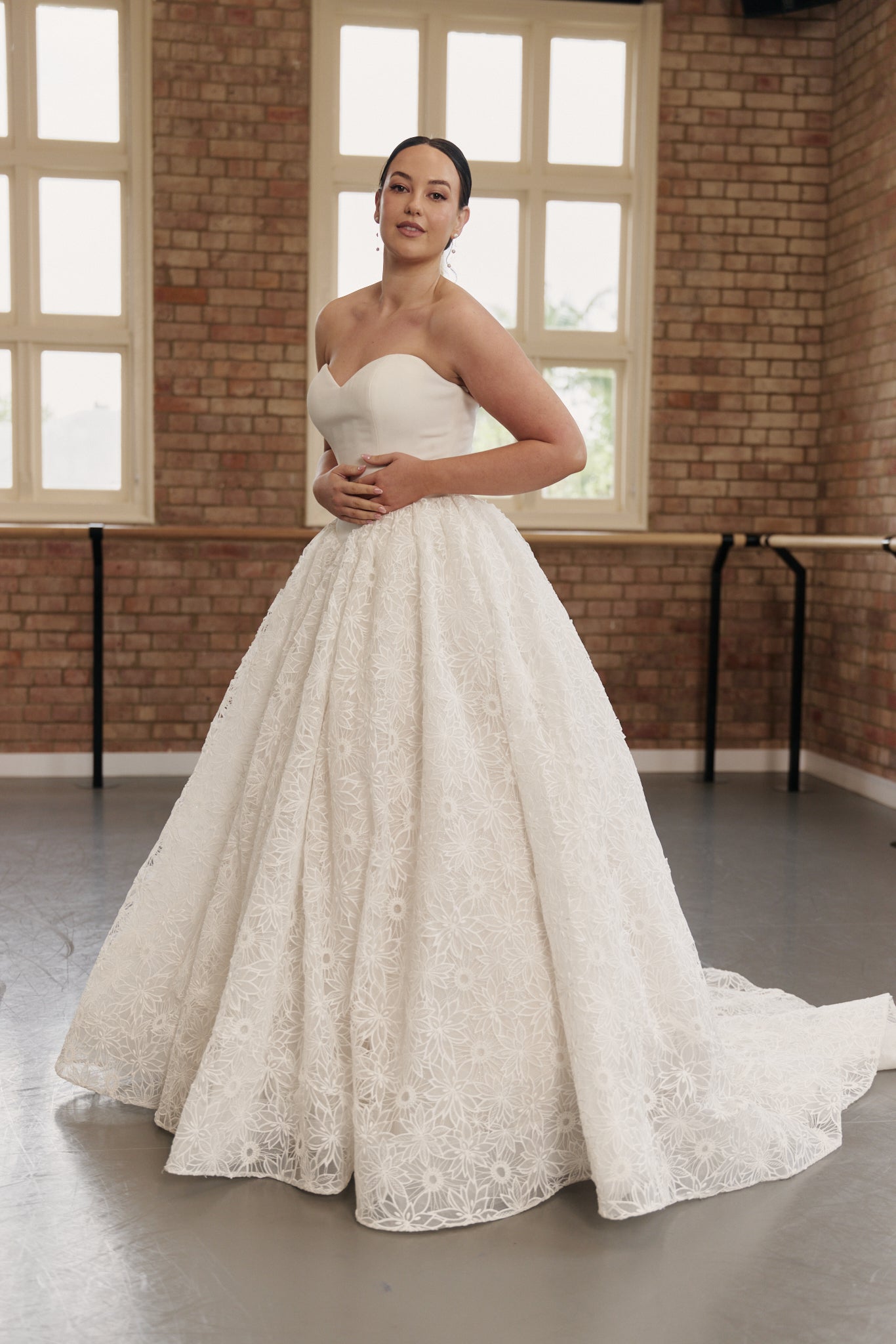 Bride wearing Danielle wedding dress with strapless sweetheart neckline, basque waist and full floral lace princess skirt.