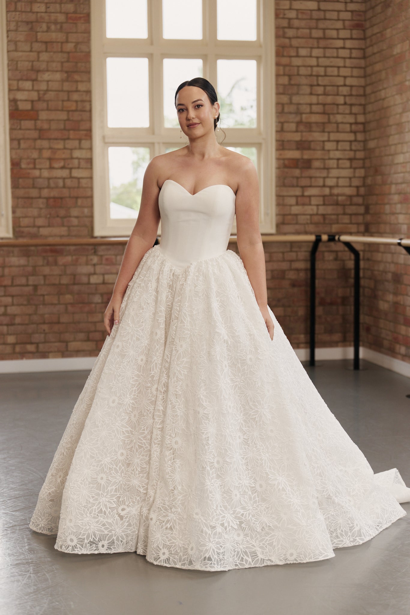 Bride wearing Danielle wedding dress with strapless sweetheart neckline, basque waist and full floral lace princess skirt