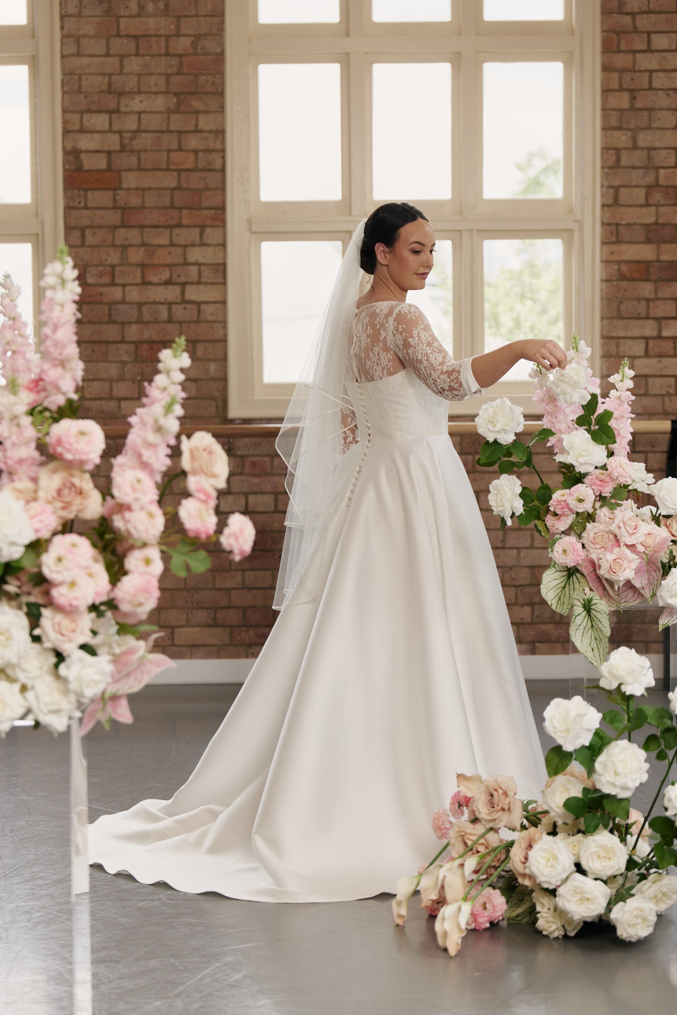 Side profile of the Elizabeth gown highlighting the soft lace texture, structured silhouette, and refined tailoring.