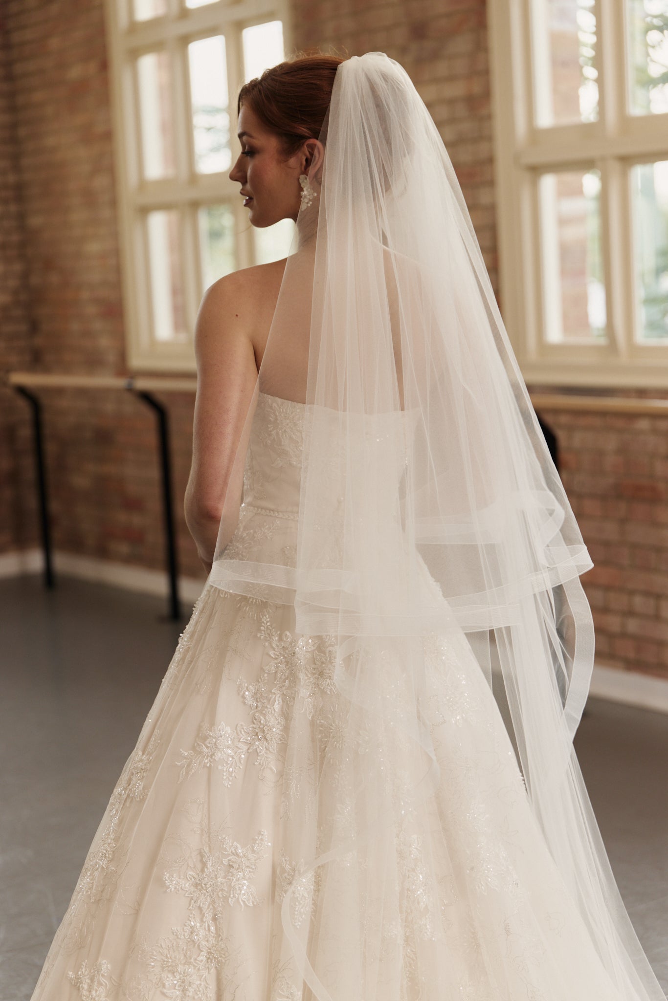 Back view of the Elodie bridal gown showcasing dramatic train, beaded bodice, and princess-style skirt.