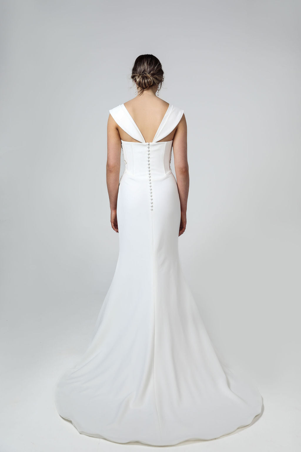 Back view of bridal gown featuring ruched bodice, optional off-the-shoulder sleeves, and medium flowing train