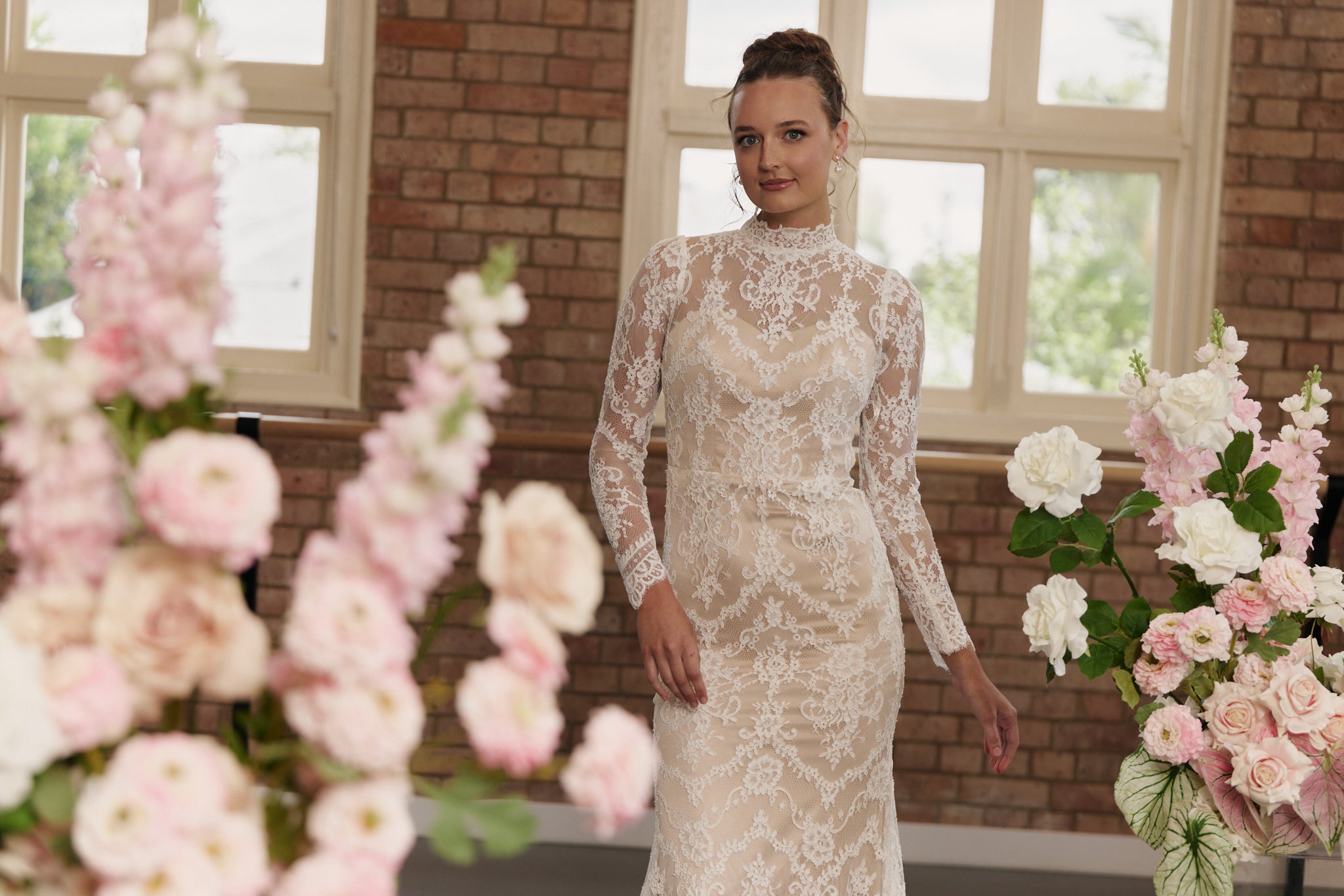 Elegant lace sheath wedding dress with high neckline and long sleeves.