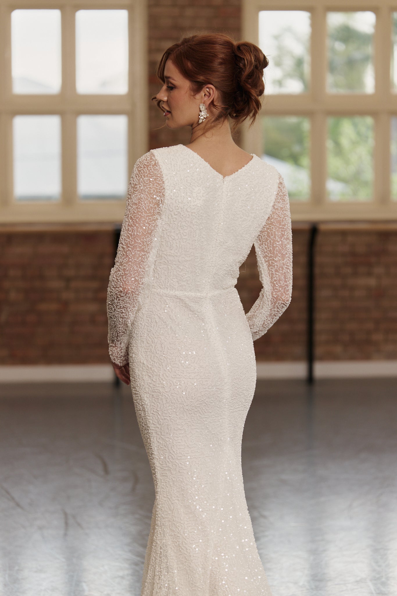 Back of Kelsey wedding dress showing long sleeves, beaded design, and gentle mermaid skirt.