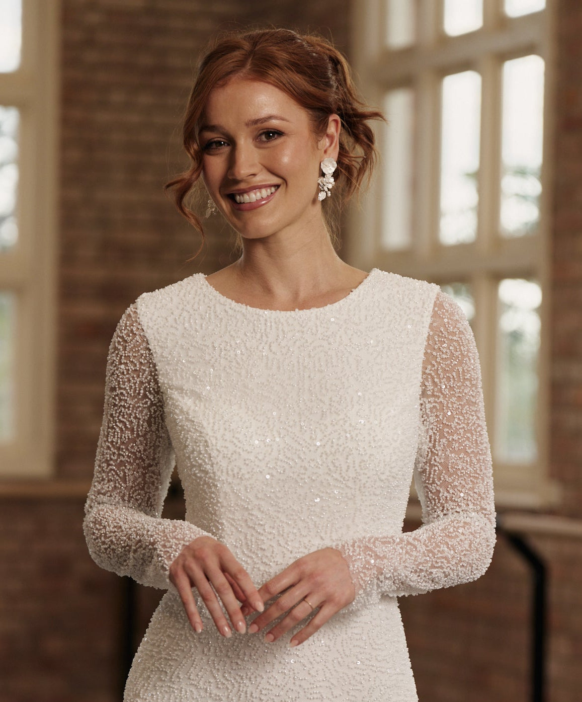 Boat neck long sleeve sheath wedding dress with delicate beadwork.