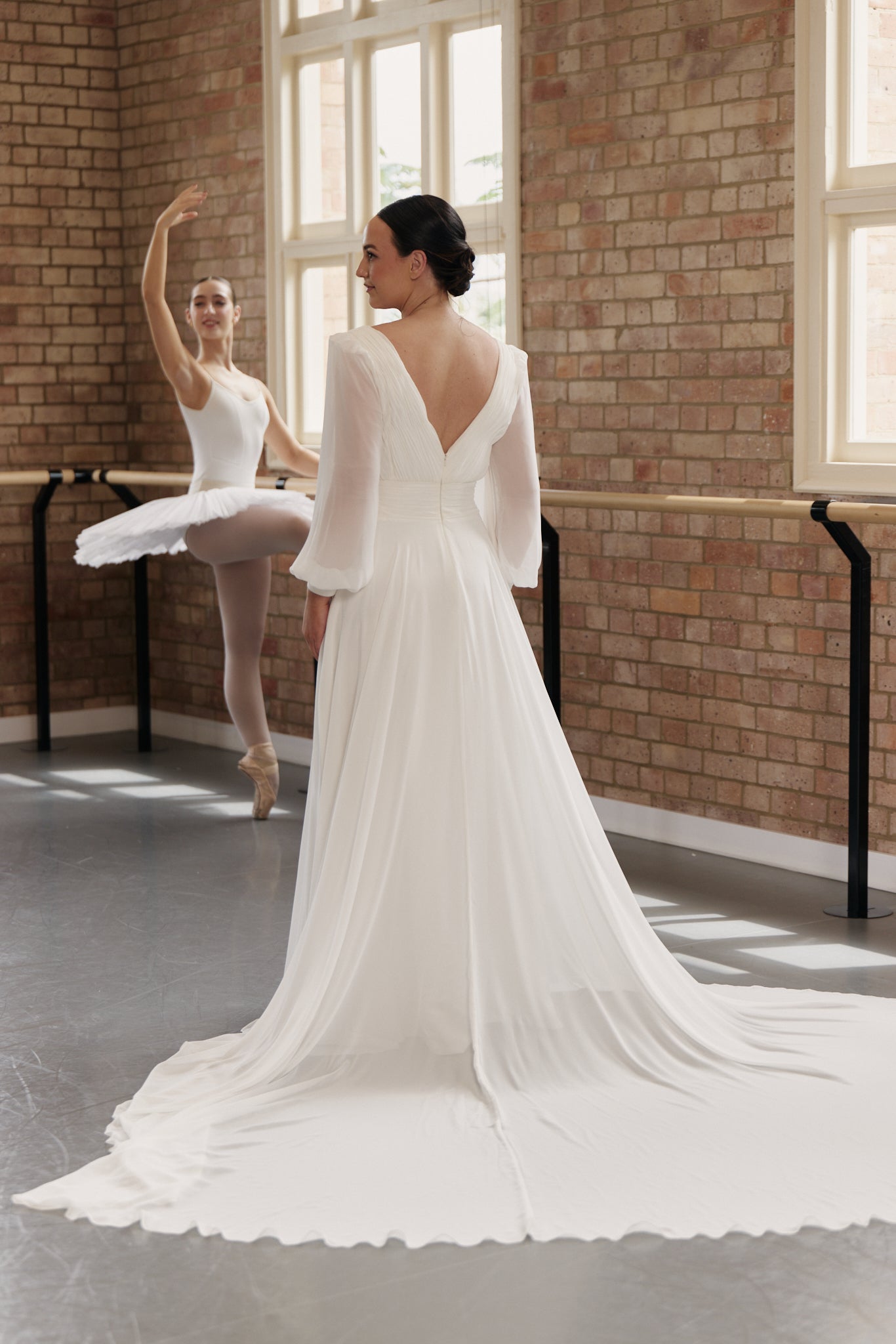 Back of Kristen pleated chiffon wrap wedding dress with bishop sleeves, and flowing A-line skirt