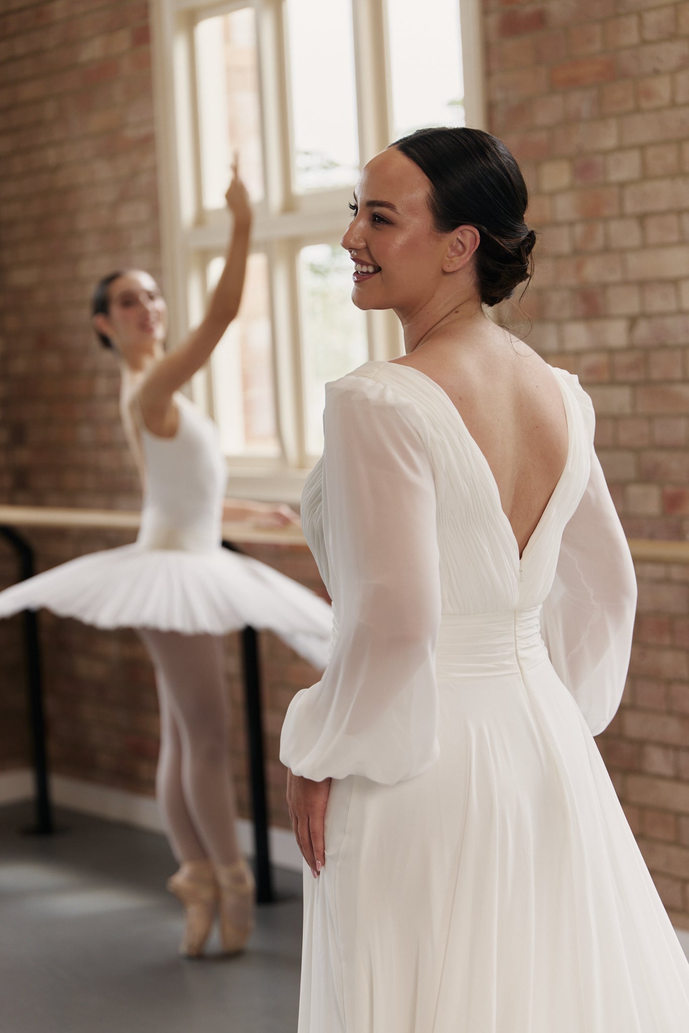 V-Back of Kristen pleated chiffon wrap wedding dress with long billowy bishop sleeves and flowing A-line skirt.