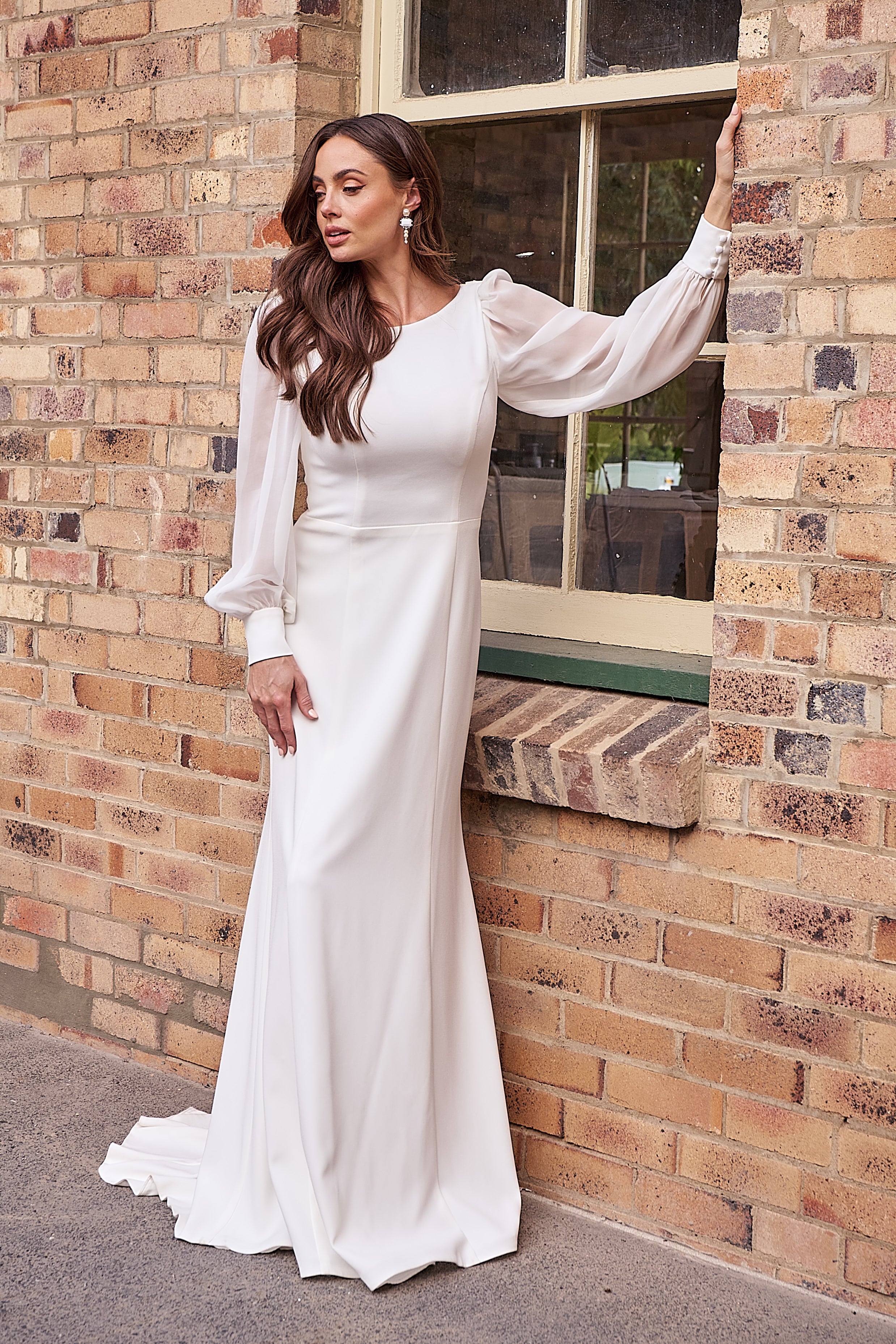 Elegant crepe wedding dress with boat neckline, flowing georgette bishop sleeves, and straight silhouette.