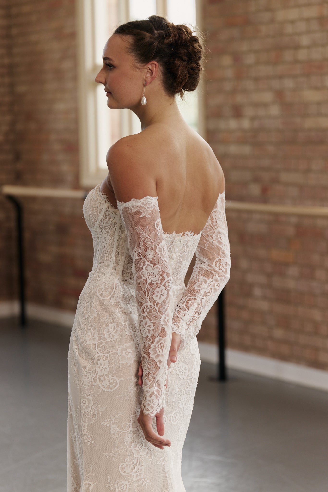Back of off-the-shoulder lace wedding gown with clean design and figure-hugging mermaid skirt.