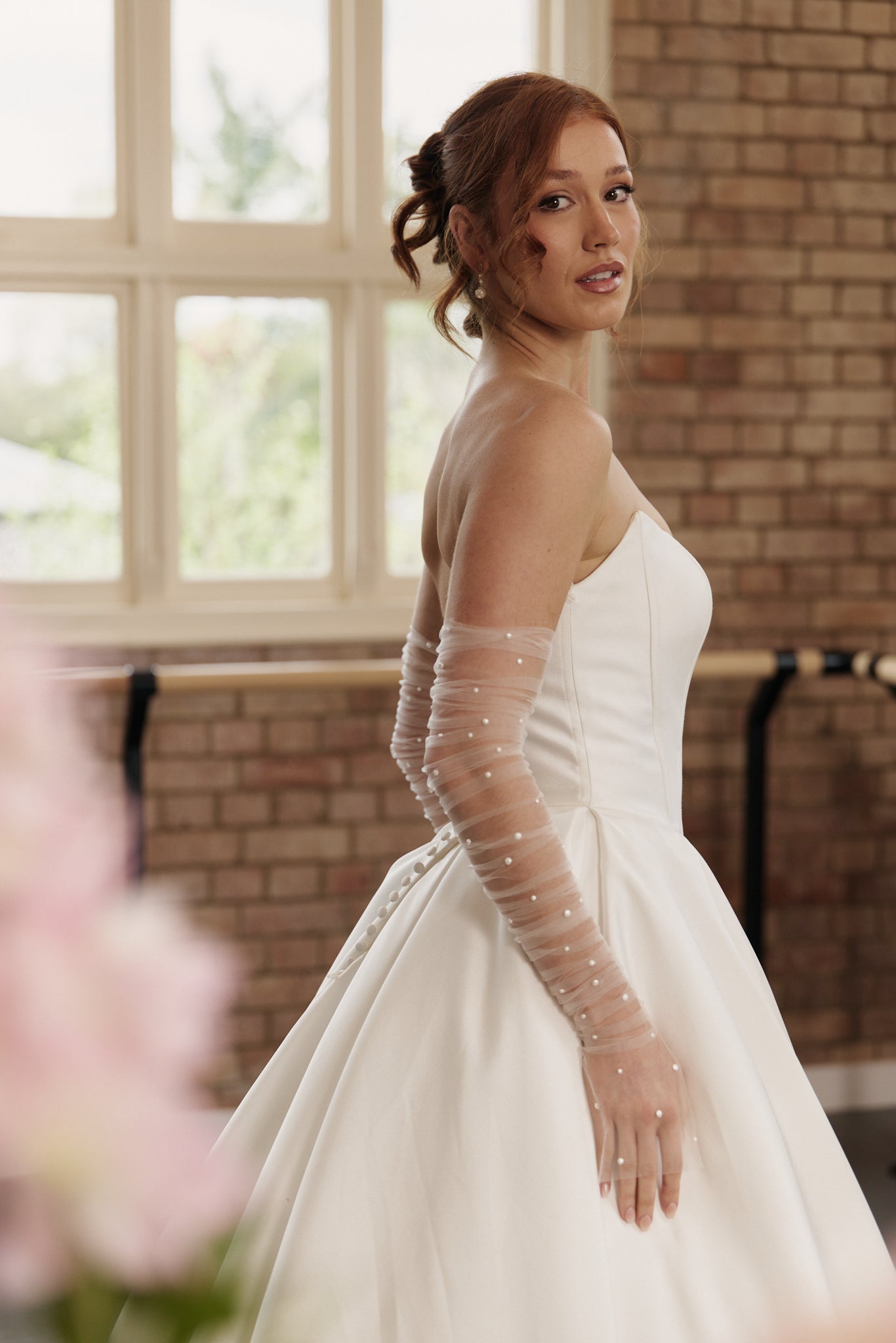 Side profile of the Mackenzie gown highlighting the fitted corset bodice, soft scoop neckline, and voluminous ball gown silhouette
