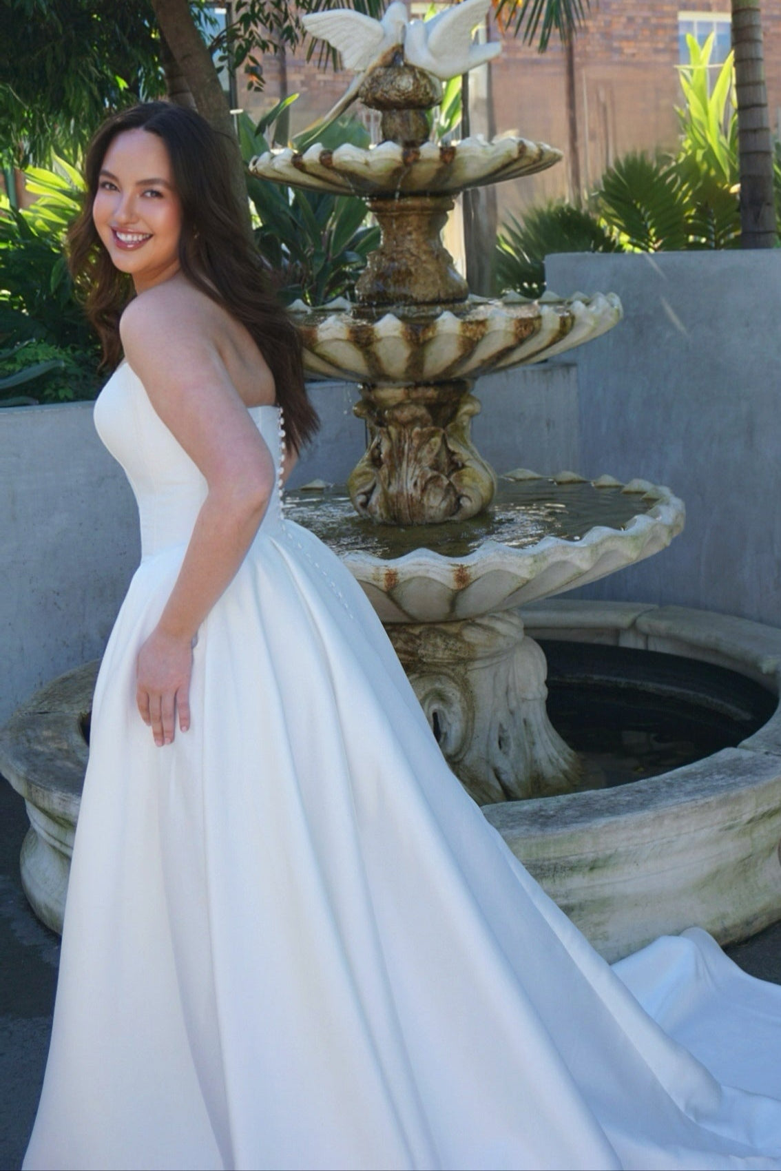 Romantic Mackenzie wedding dress with basque waist, structured corset bodice, and full princess-style ball gown silhouette.