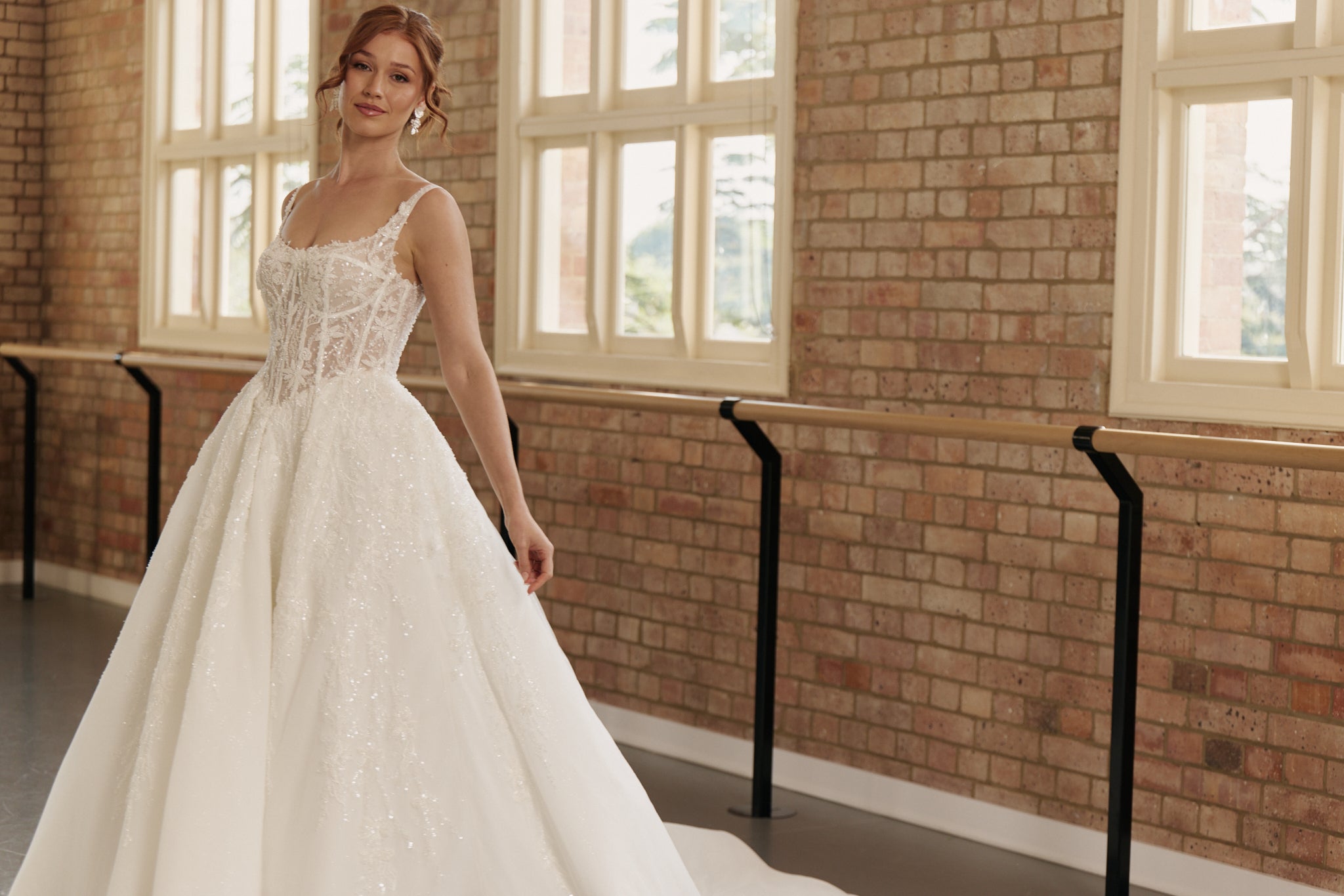 Princess style Ophelia wedding dress with corset bodice, basque waist, layered organza skirt, and lace detailing.