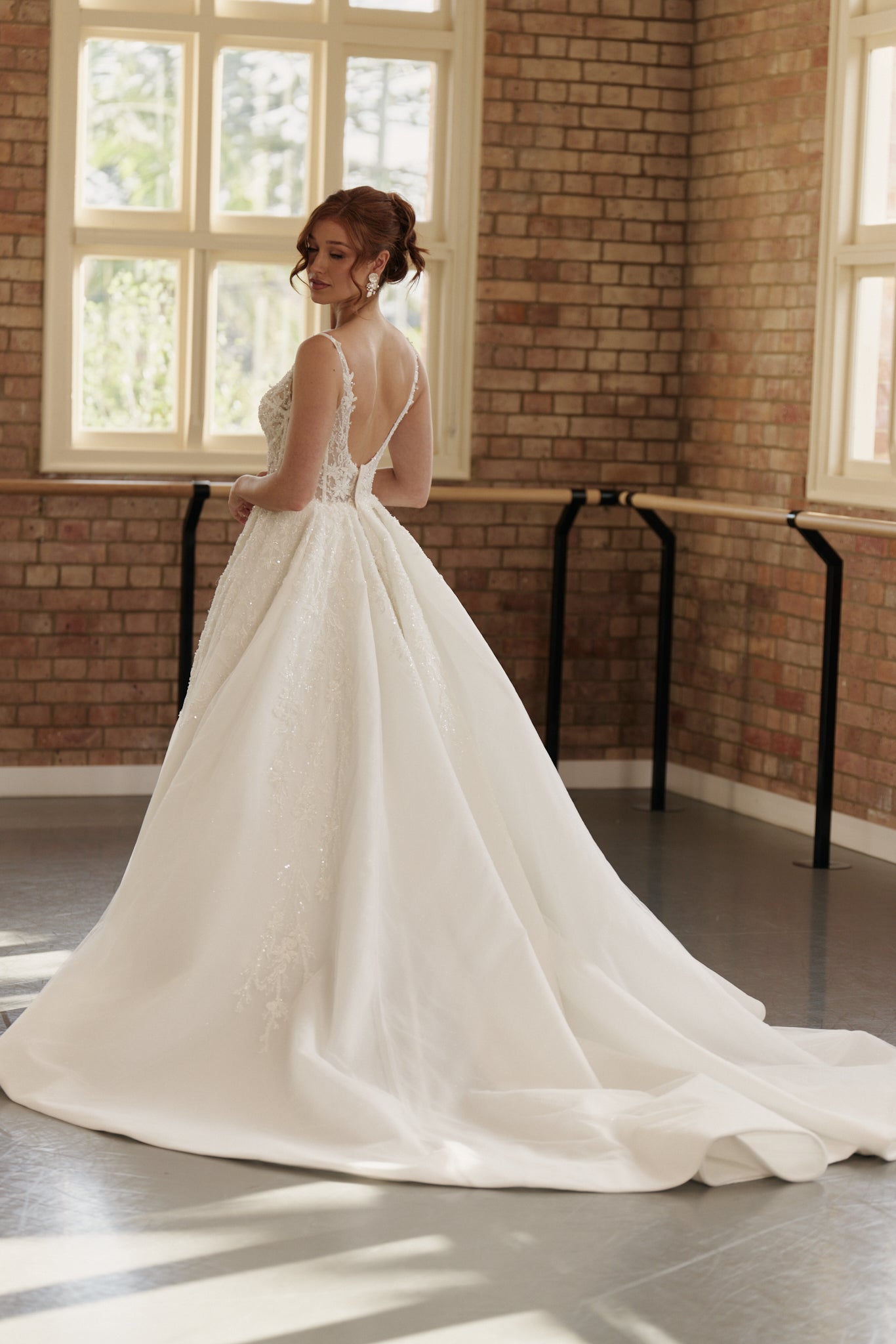 Back view of the Ophelia bridal gown showcasing beaded bodice with basque waist and layered organza skirt.