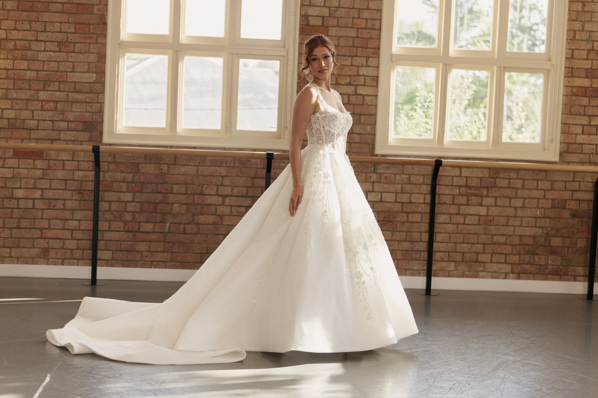 Side profile of the Ophelia gown, embellished corset bodice, basque waist, and flowing organza layers.
