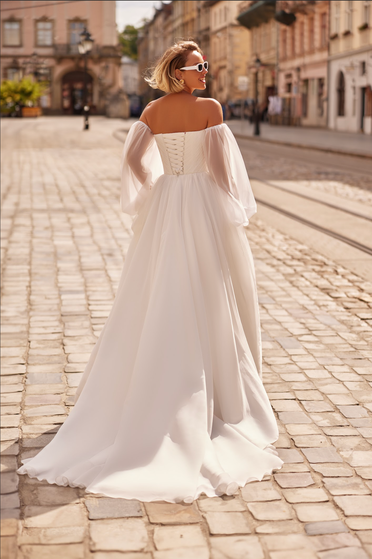 Petra Wedding Gown, Corset bodice, a line silhouette, draped ing light chiffon fabric, strapless with billowy chiffon sleeves.