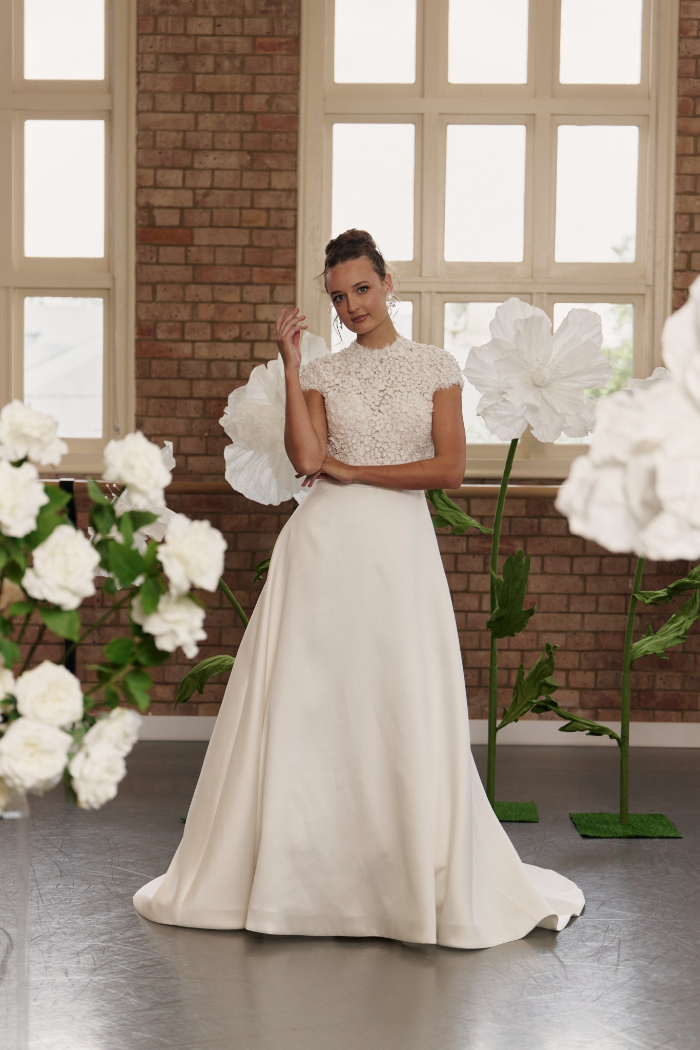 Front view of classic wedding dress with 3D floral lace bodice, cap sleeves, high neckline, and mikado A-line skirt.