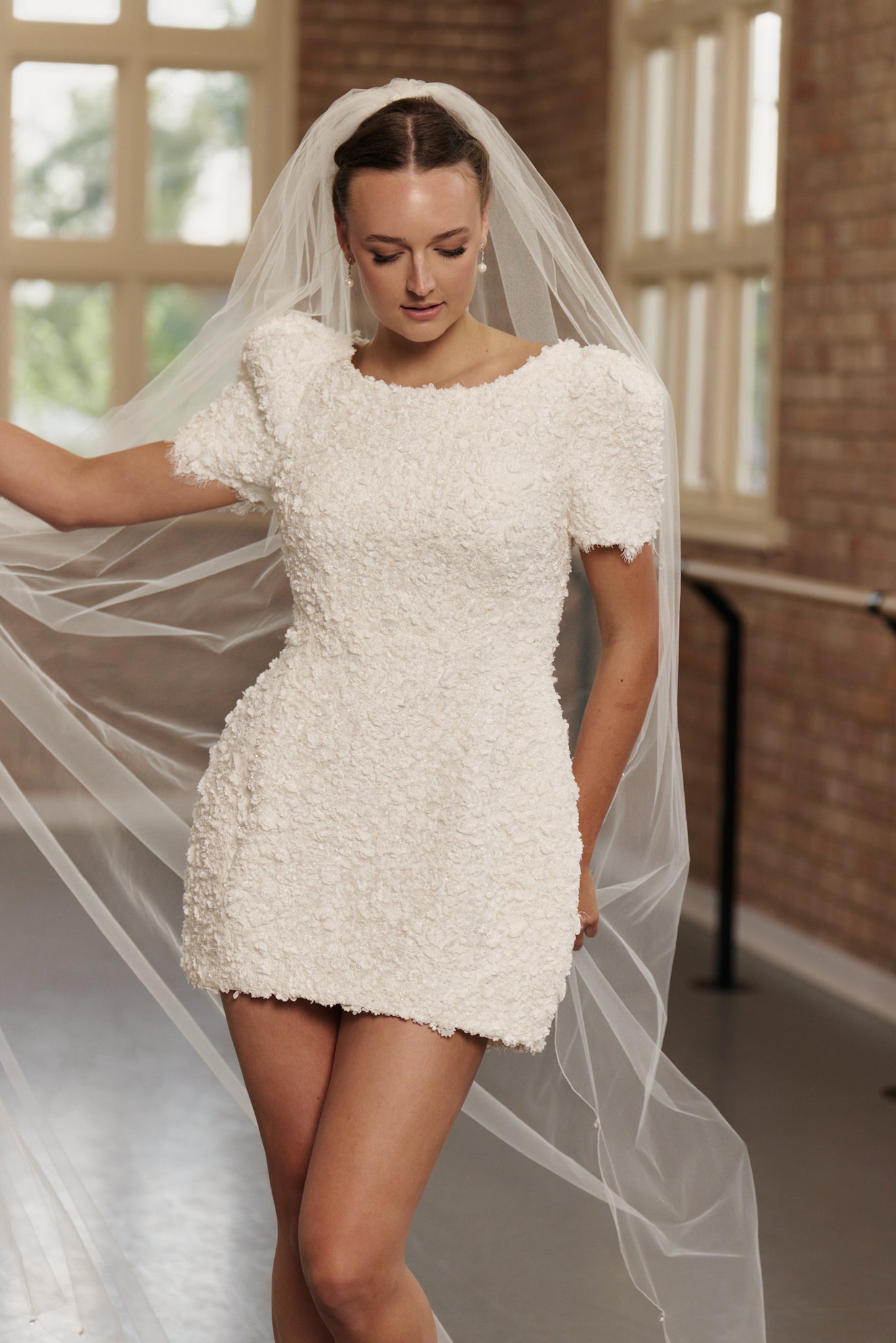 Close-up of the Poppy dress' textured floral lace and oversized cap sleeve detail with veil