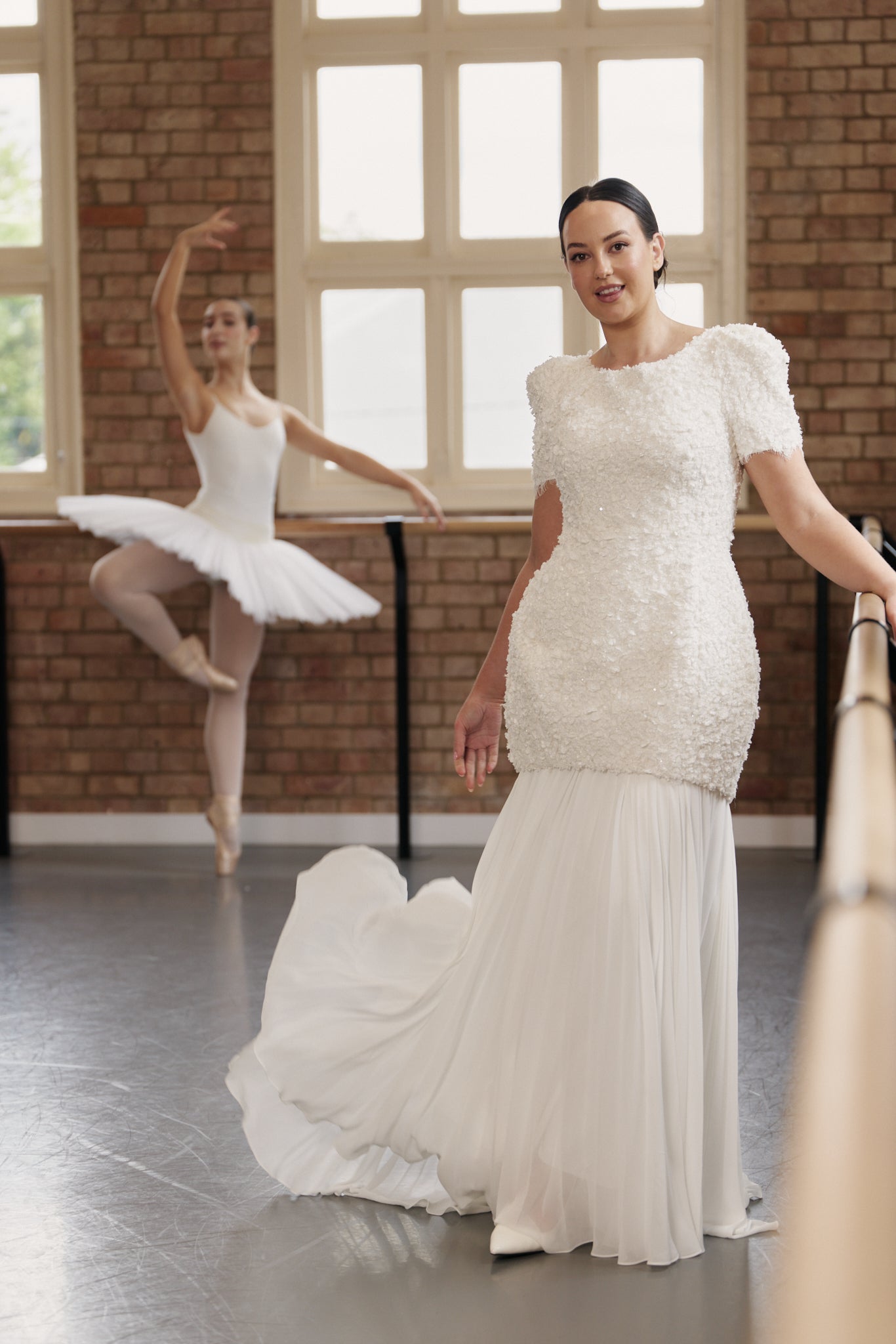 Poppy mini wedding dress with rounded skirt, oversized cap sleeves, and textured floral lace. With sunray pleated chiffon underskirt.