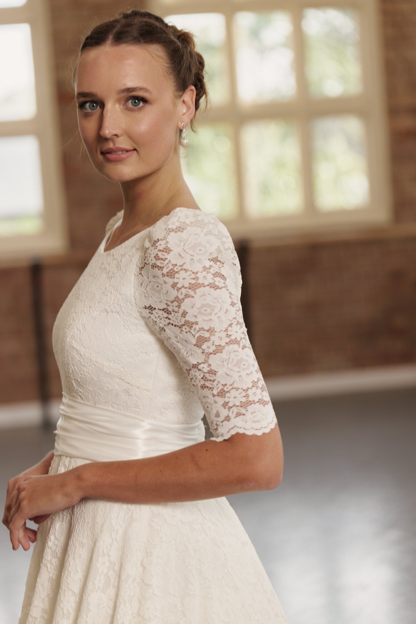 Close-up of the Roma gown’s lace detailing and ruched silk waistband, emphasising lace sleeve detail