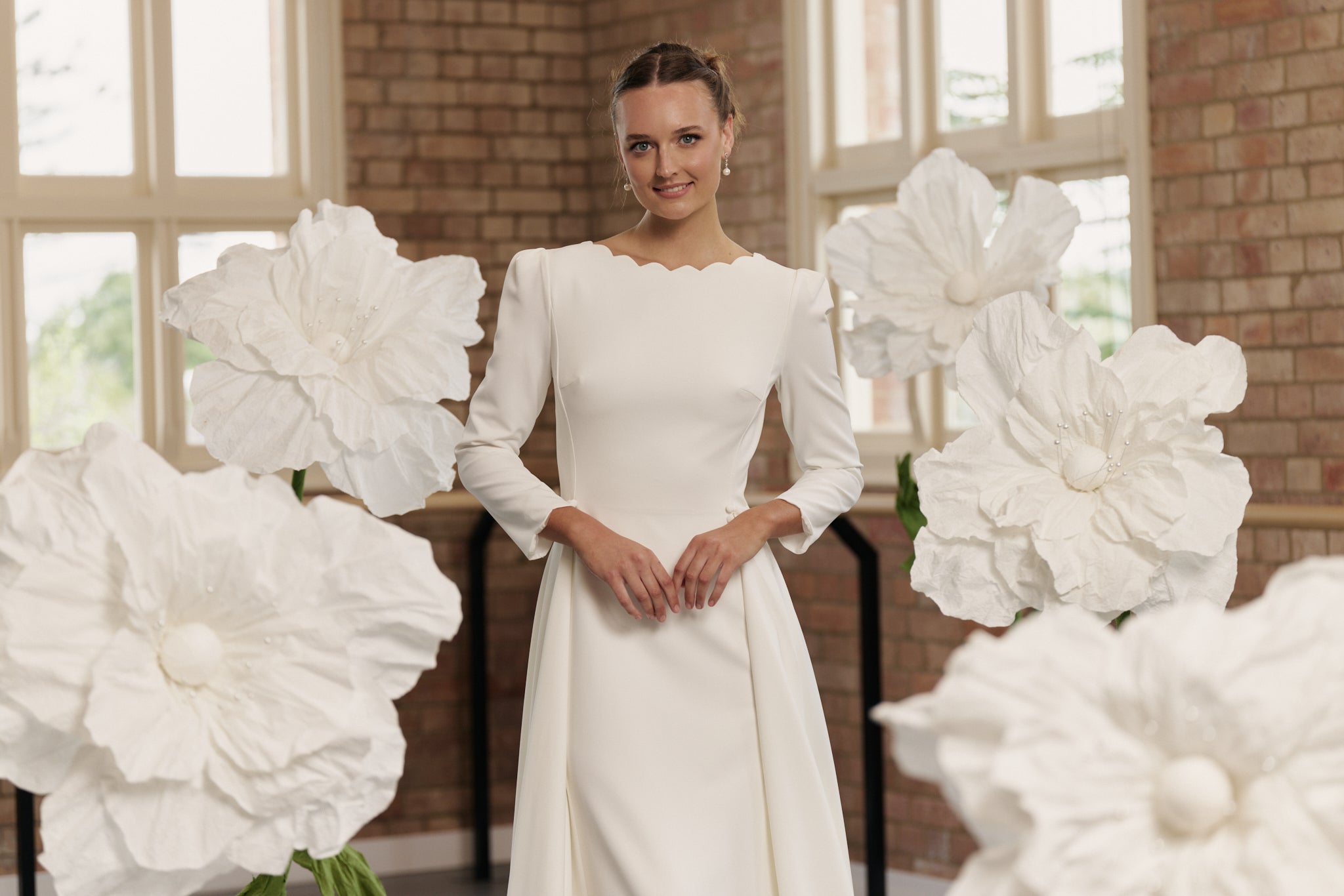 Close-up of Shari gown’s scalloped boat neckline and delicate 3/4 sleeve detailing.
