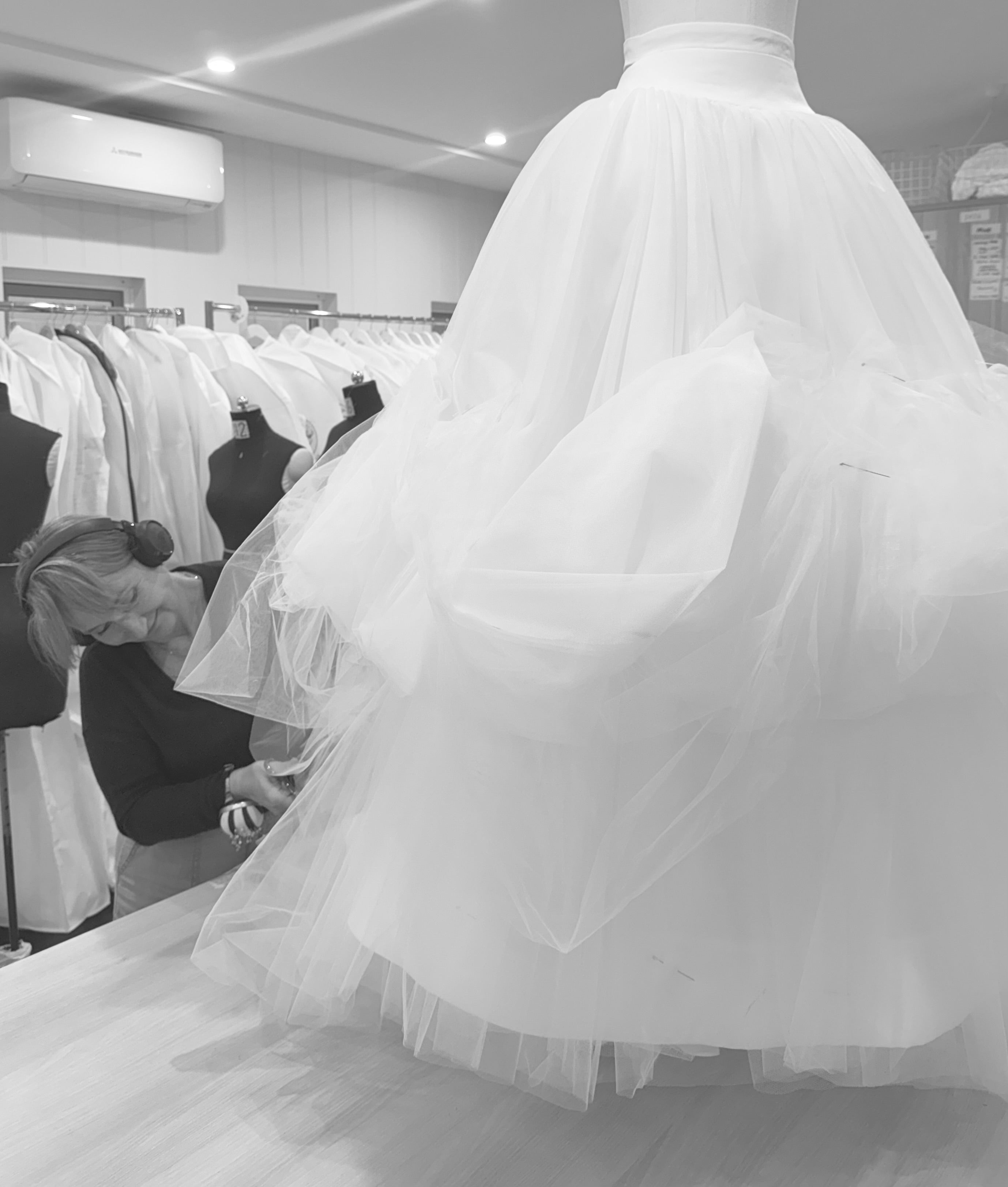 Close-up of bridal gown alteration in progress, tailoring dress for flawless fit.