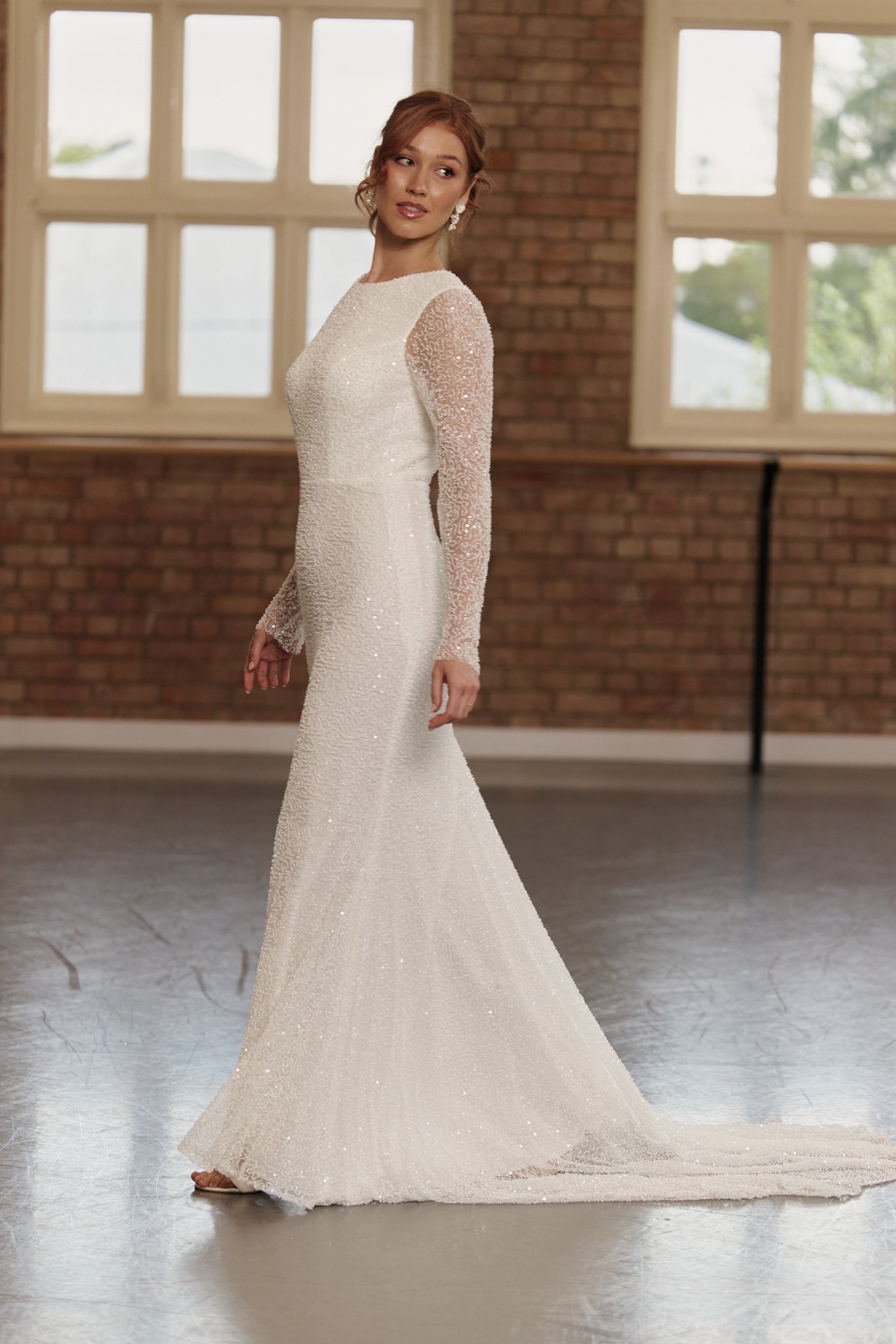 Side view of boat neck long sleeve beaded sheath wedding dress.