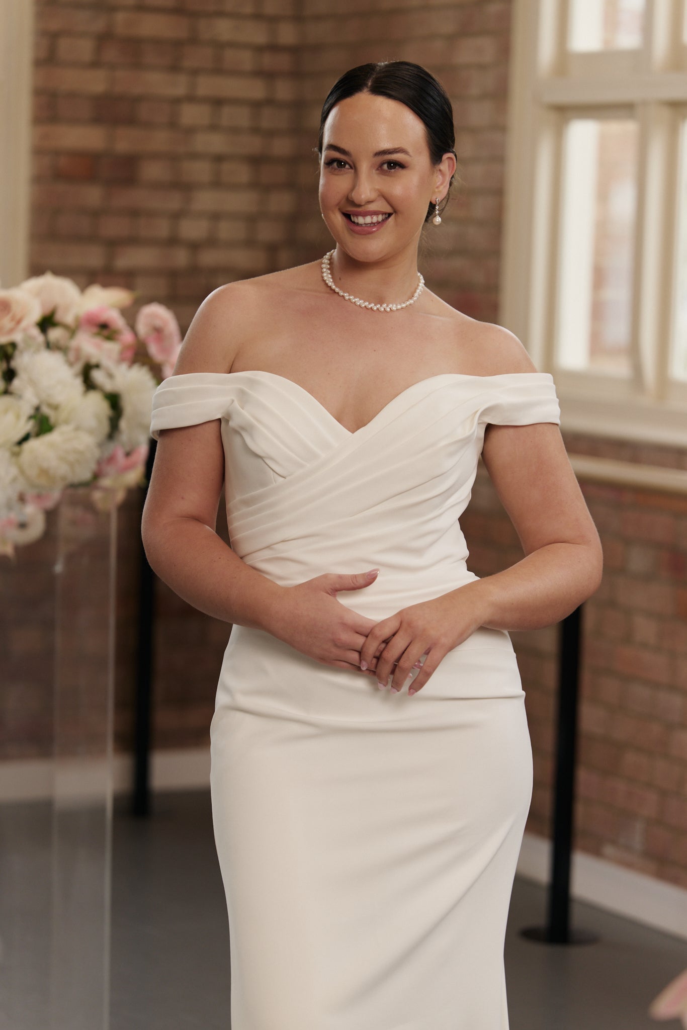 Sleek mermaid bridal gown with off-shoulder neckline and flattering pleated bodice for modern brides.