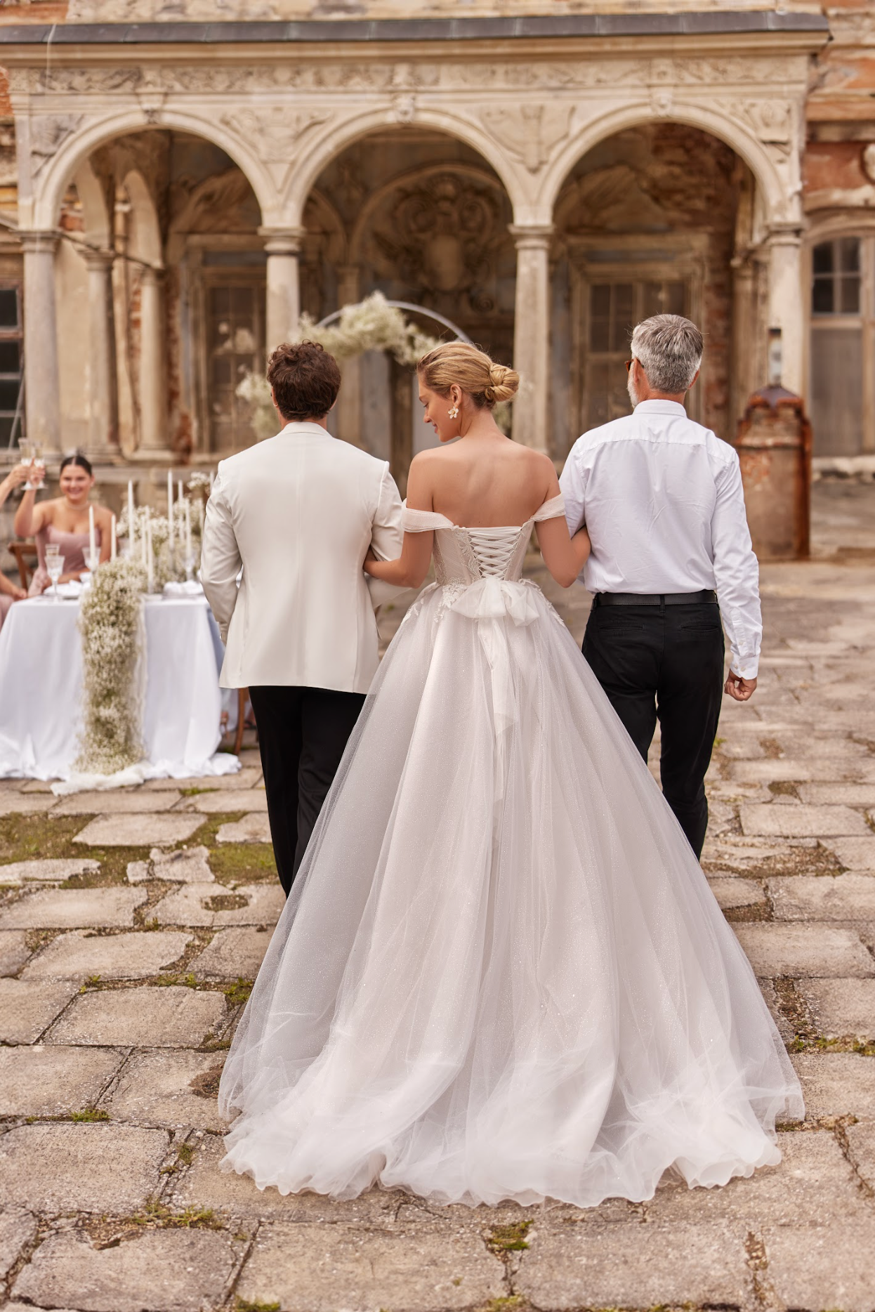 Vesta Wedding Gown, corset bodice with pleated ruching across bodice, flowy tulle skirt, detachable long sleeves, sweetheart neckline, strapless, delicate bow at waist.