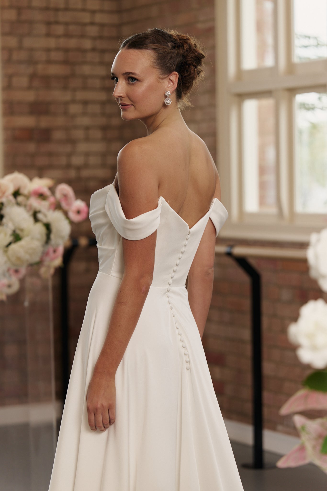 Back of Anne wedding dress showing button down back and flowing A-line crepe skirt