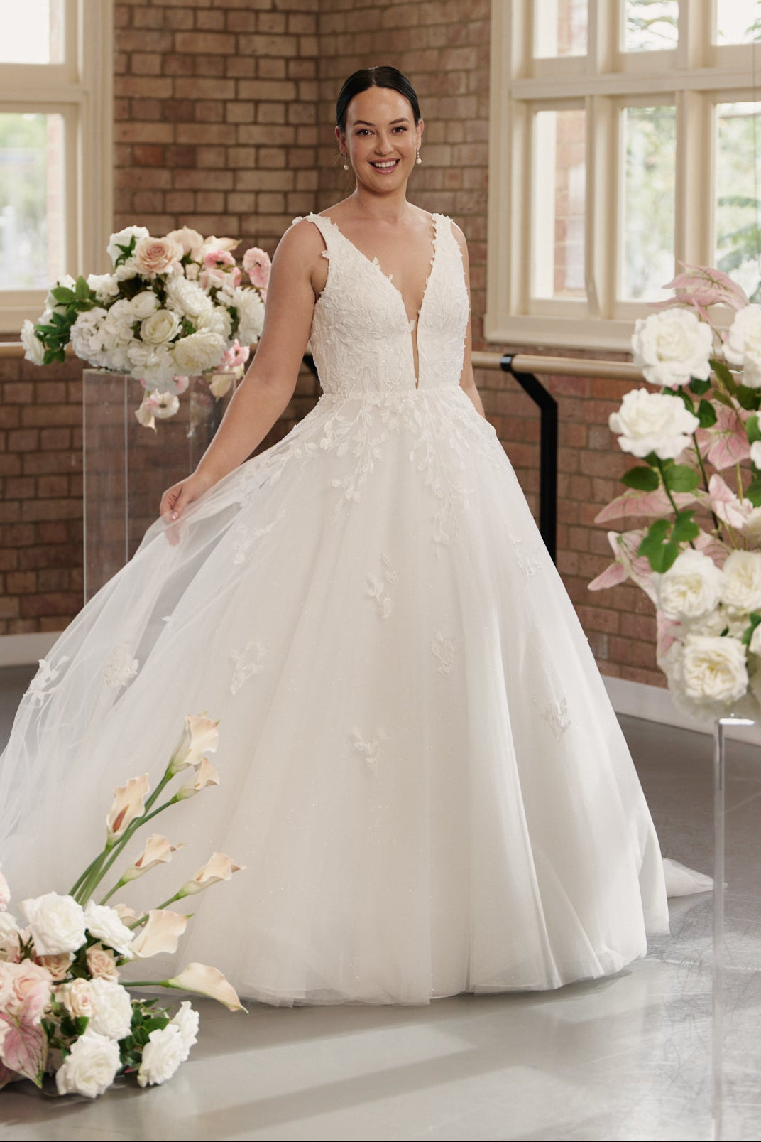 Bride wearing Celine V-neck wedding dress with princess ball gown silhouette and embroidery.