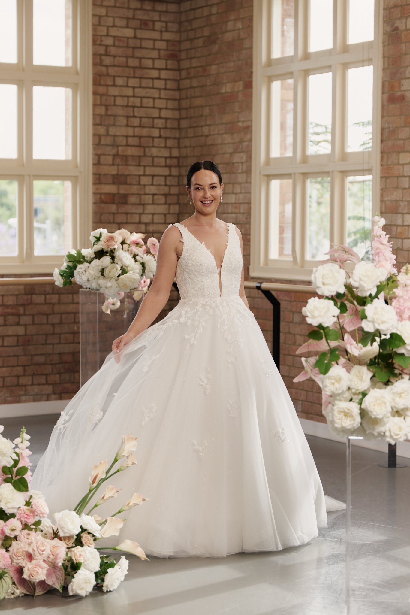Bride wearing Celine V-neck wedding dress with princess ball gown silhouette and embroidery.