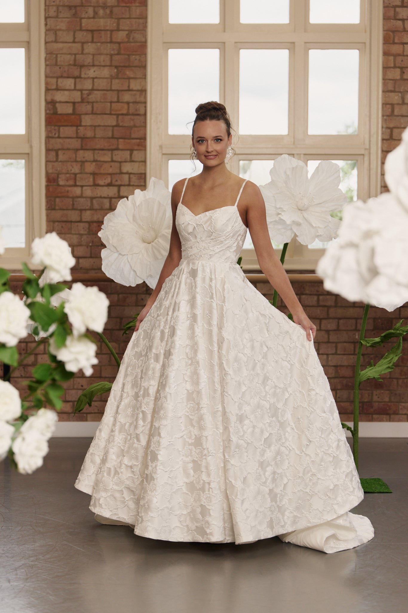 Floral jacquard wedding dress with V-neck, thin spaghetti straps, structured bodice, cinched waist, and full circle skirt.