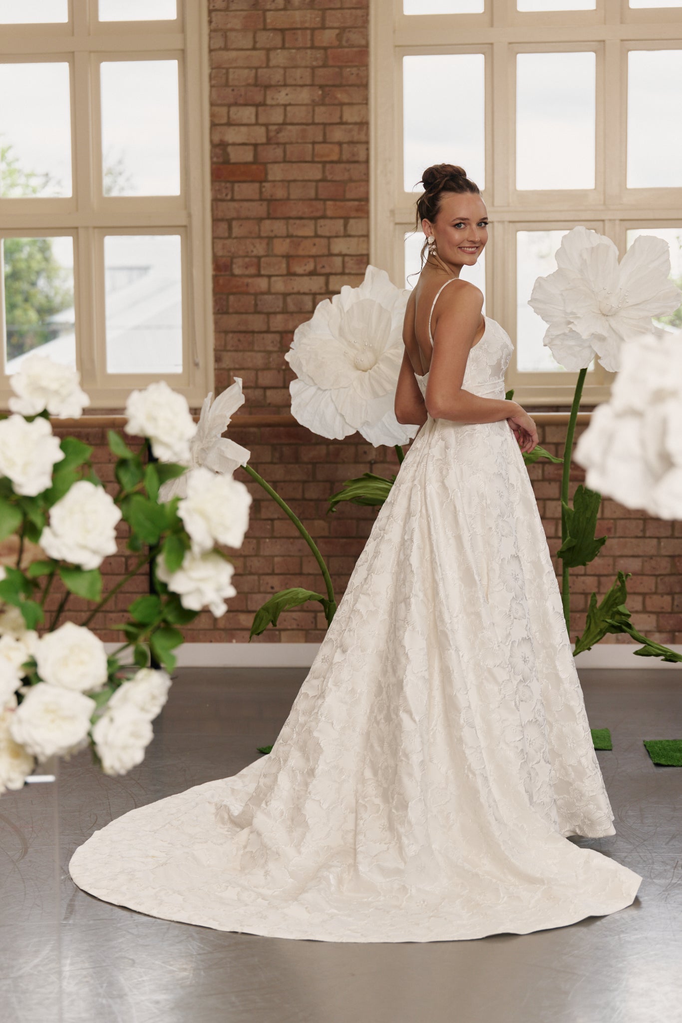 Back of floral jacquard wedding gown showing spaghetti straps, structured bodice, and full circle skirt with optional train
