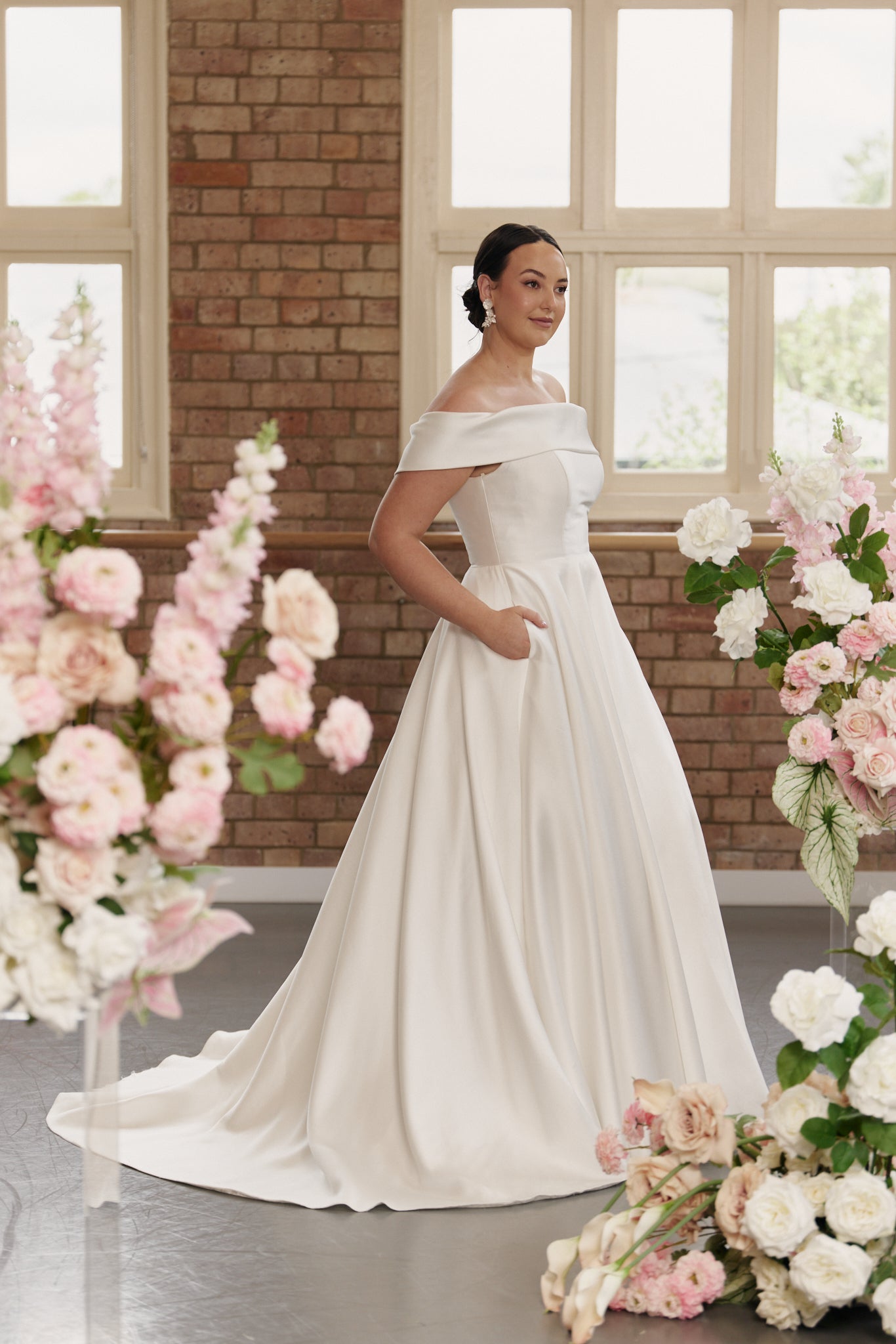 Side profile of the Christie gown highlighting the structured off-shoulder neckline and flattering full A-line skirt.