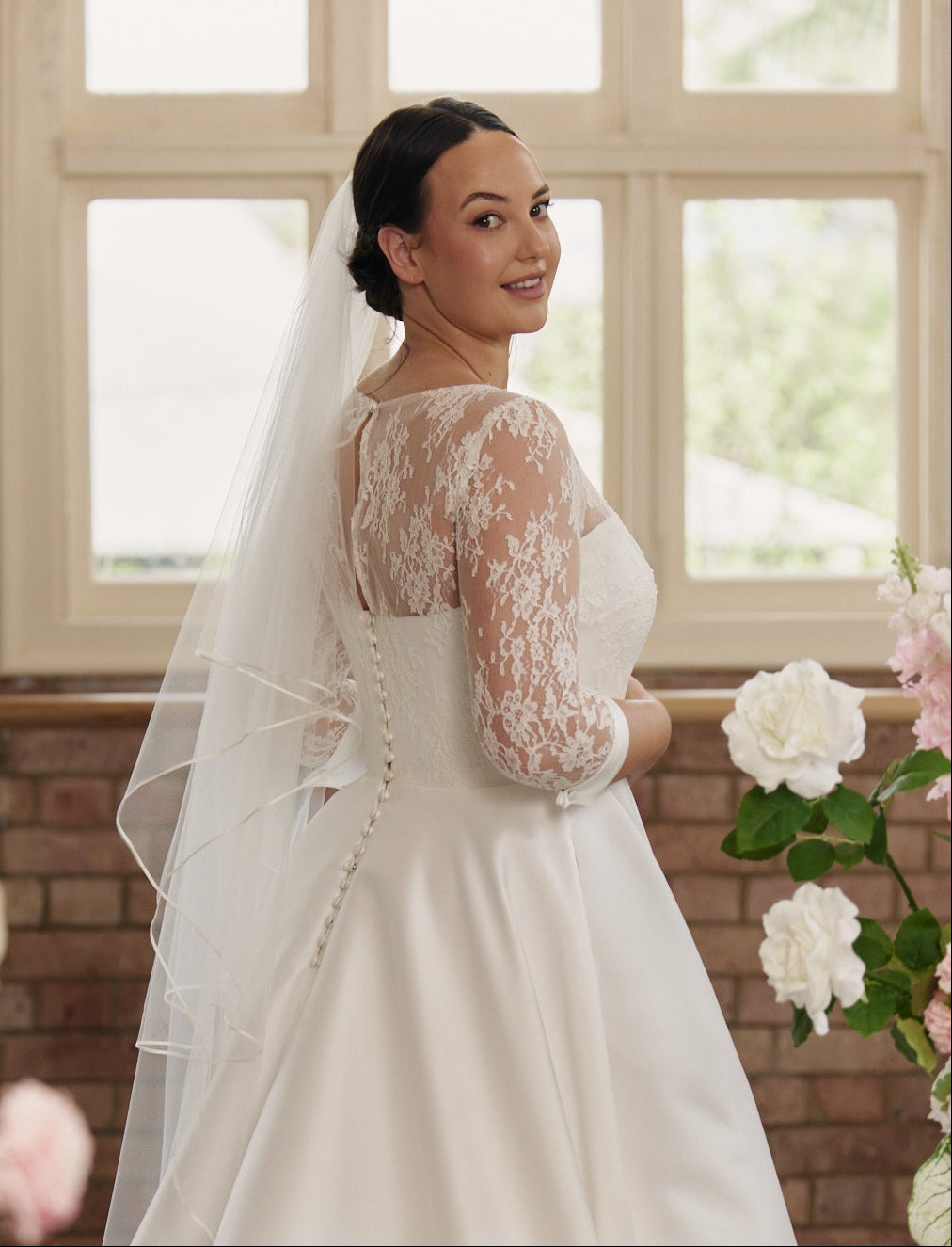 Back view of the Elizabeth bridal gown showing optional V-back or high-back design with delicate button details.