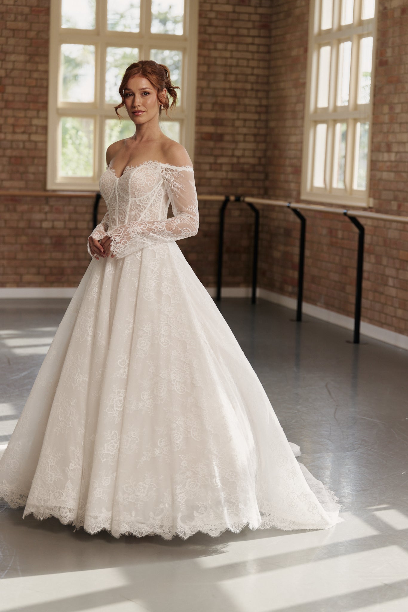 Elle wedding dress in full lace with off-shoulder long lace sleeves, corseted bodice, and princess-style skirt