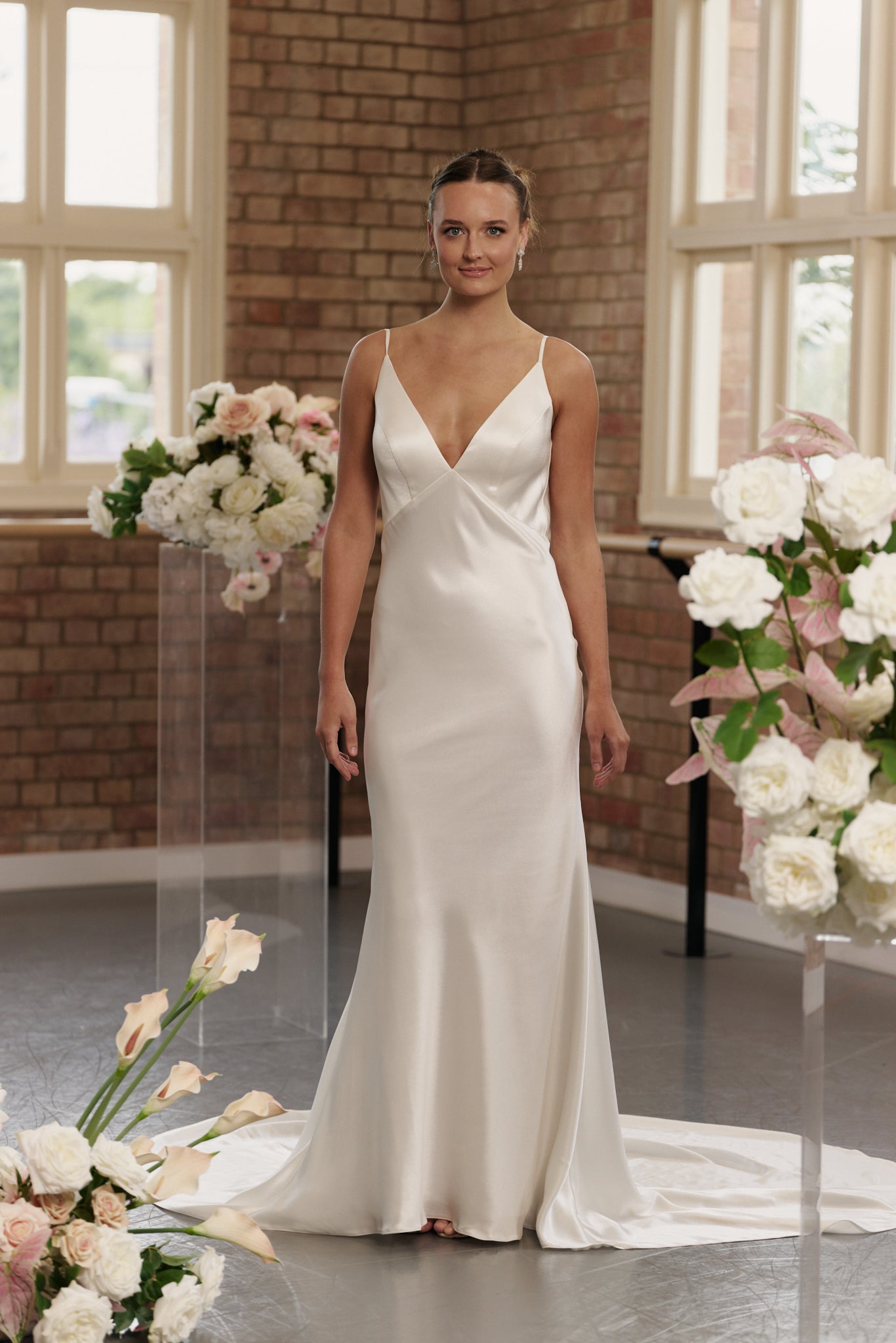 Bride wearing Gabrielle sheath satin wedding gown with V-neck, backless low cowl, and spaghetti straps.