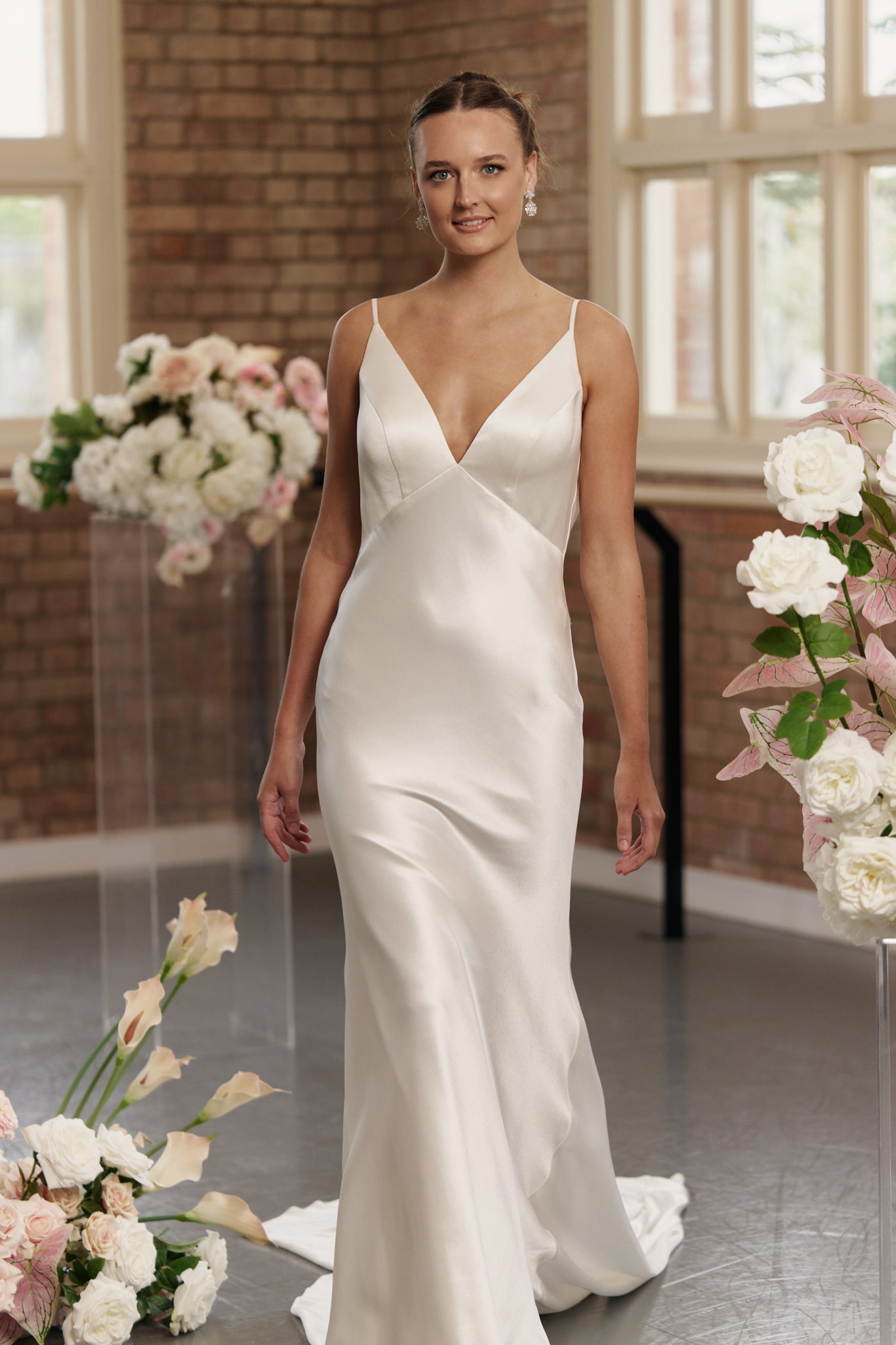 Close-up of V-neck bodice and low cowl back on Gabrielle satin sheath wedding gown.