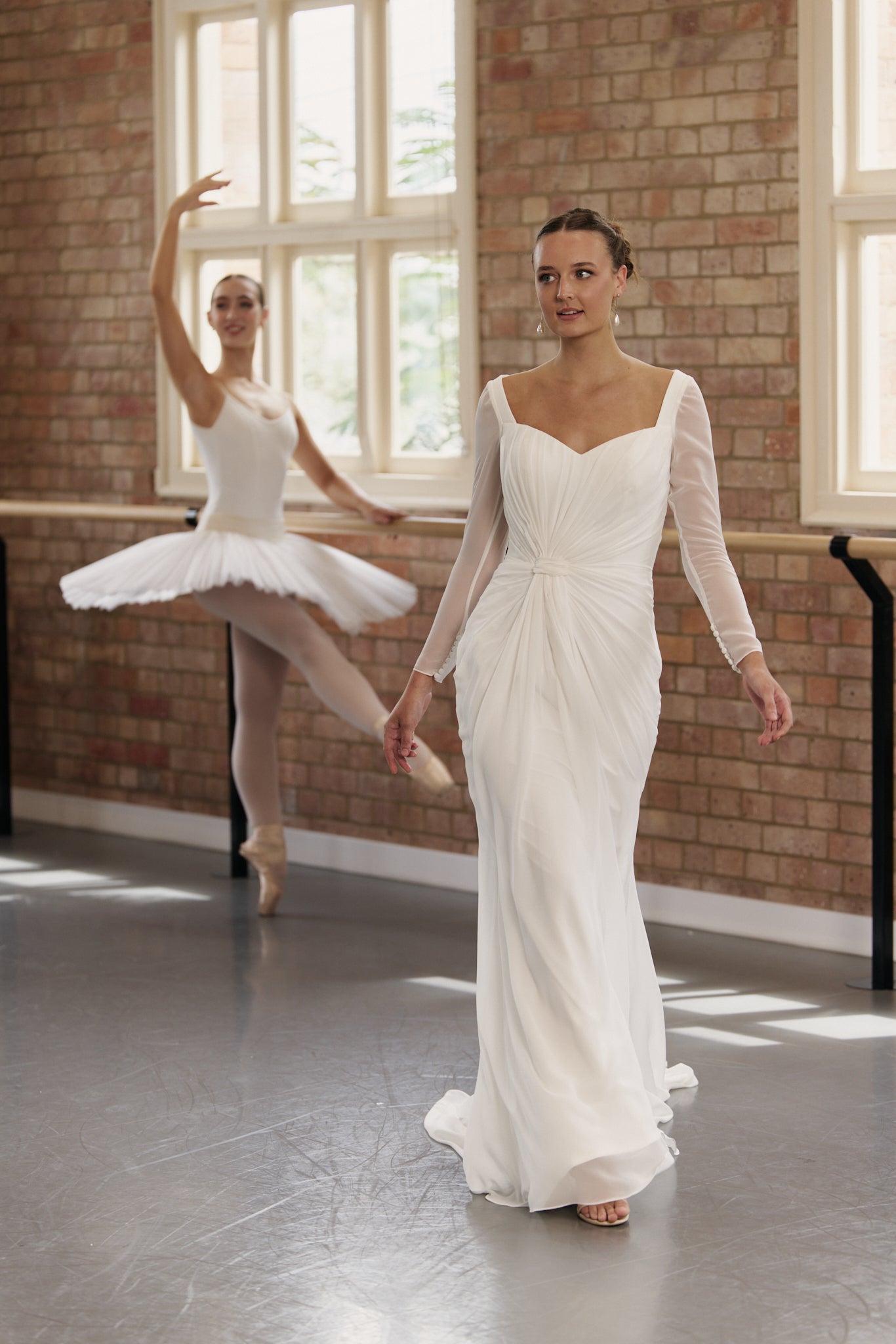 Bride wearing Gigi sheath-style wedding dress in soft chiffon with long sleeves and column silhouette showing floaty, flowing movement.