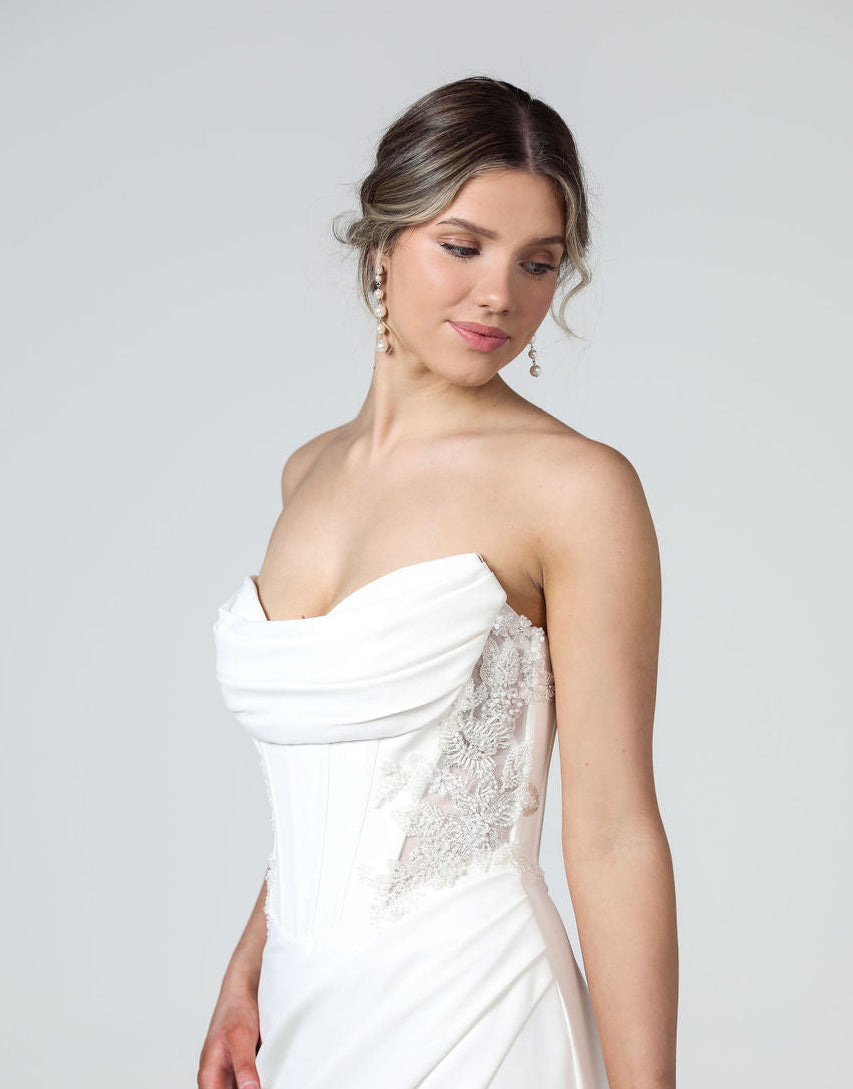 Side profile of strapless gown highlighting ruched bodice, beaded detailing and high leg split.