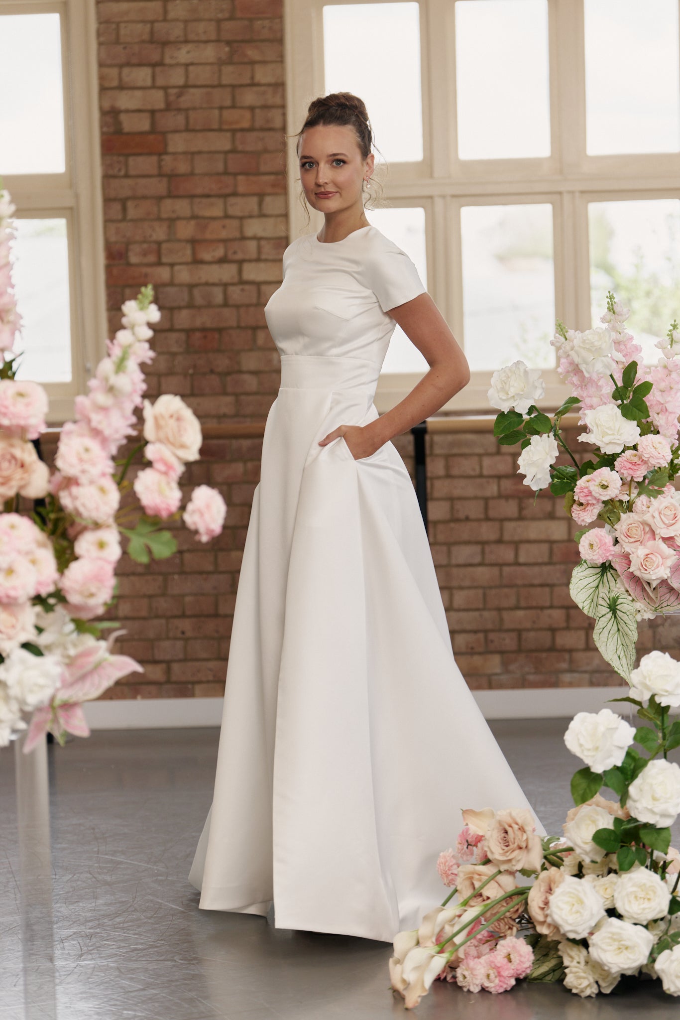 Side view of Jane wedding dress showing full skirt with split, short sleeves, and round neckline.